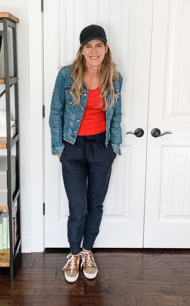 black joggers with a red top and denim jacket