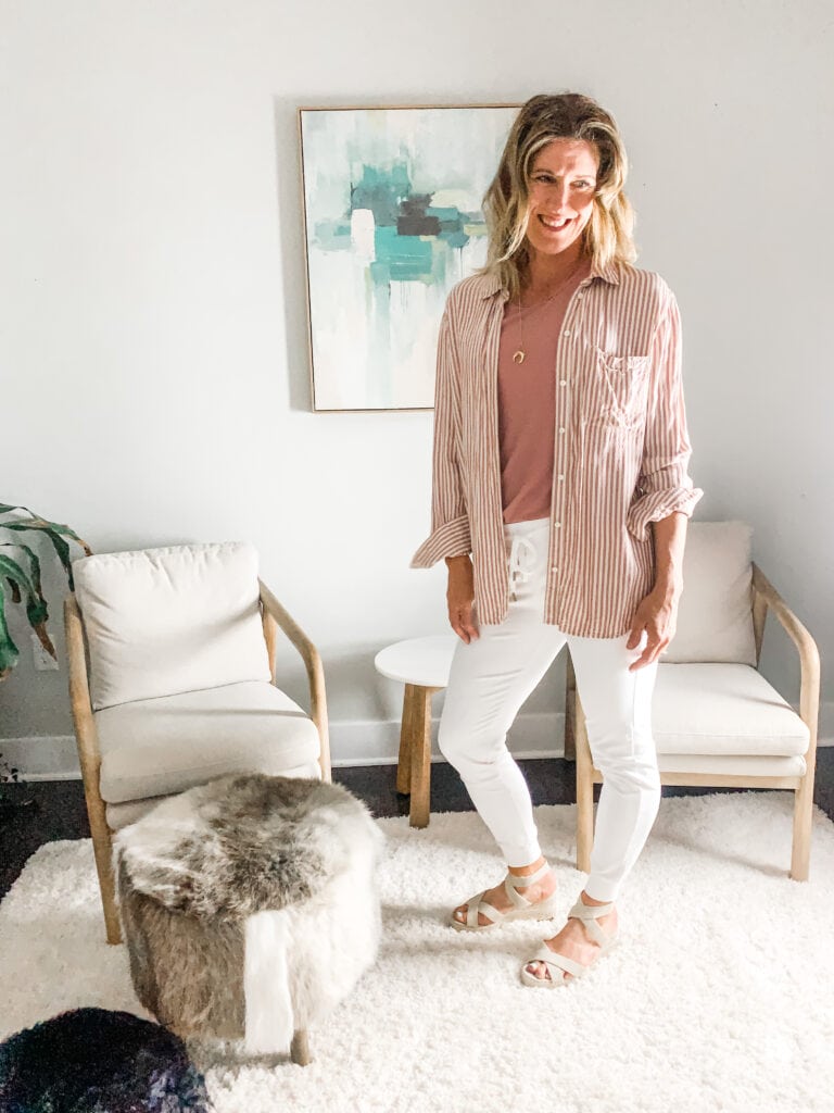 a woman in white joggers with sandals and a button down top