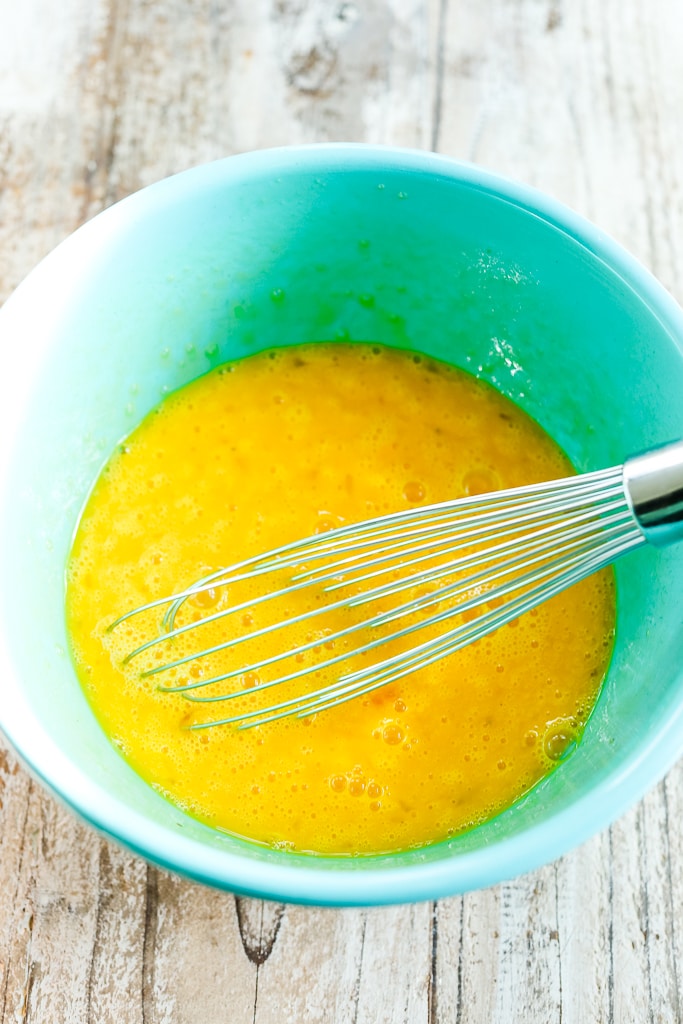 egg mixture with a whisk in a blue bowl
