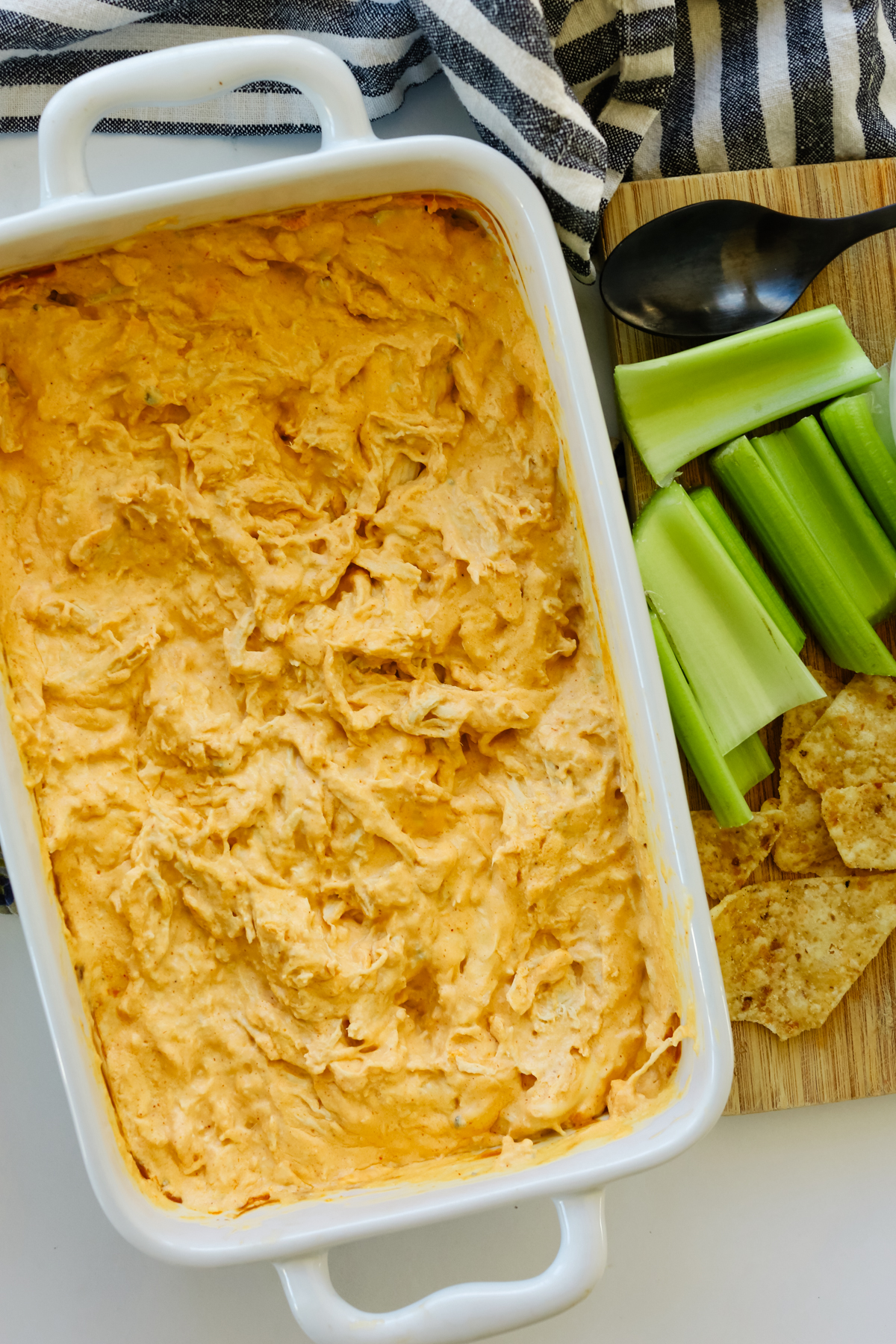 healthy buffalo chicken dip in a white baking container 