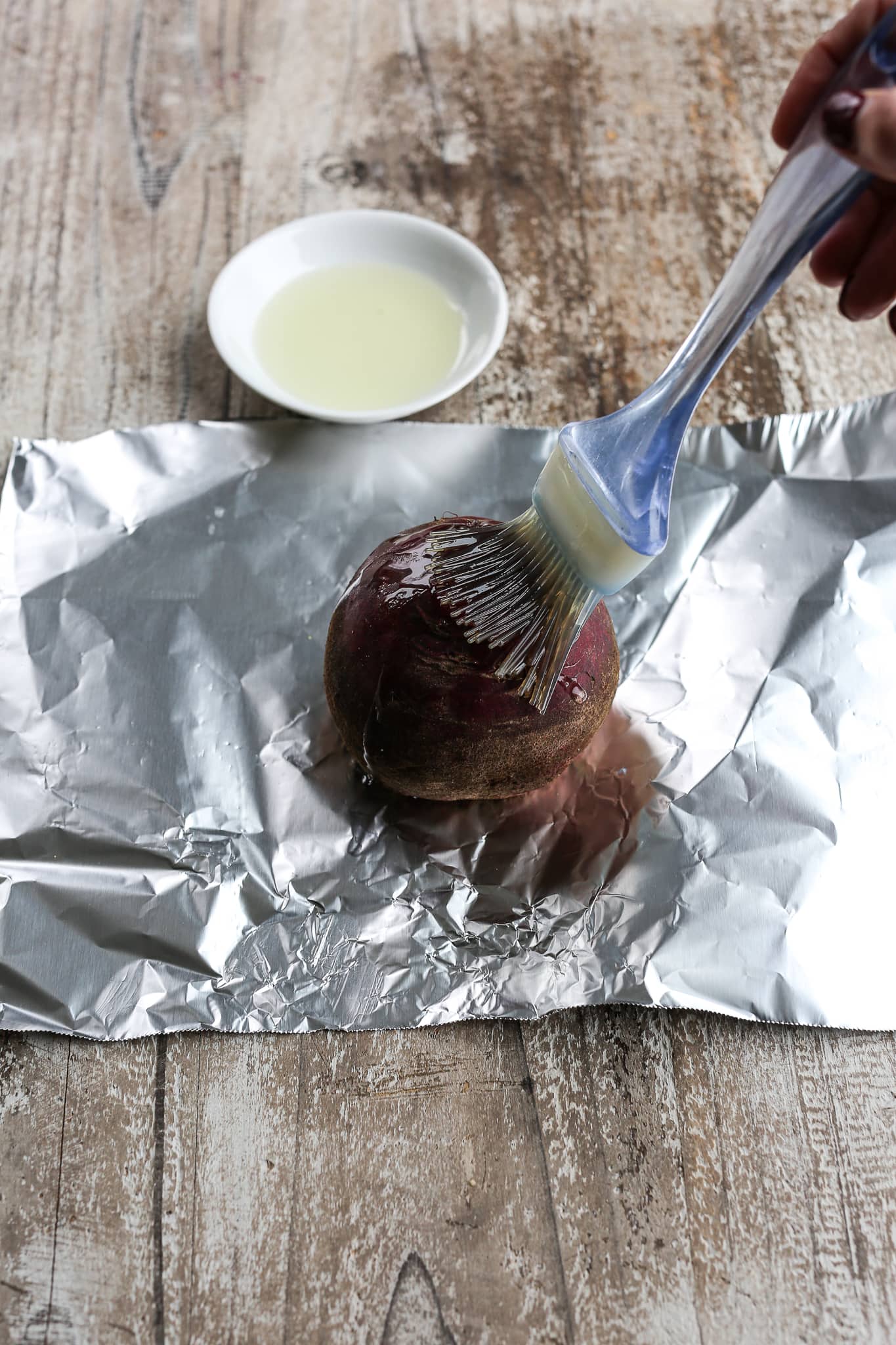 brushing oil on a raw beet