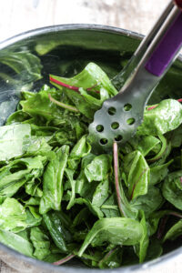 tossing the greens in a bowl