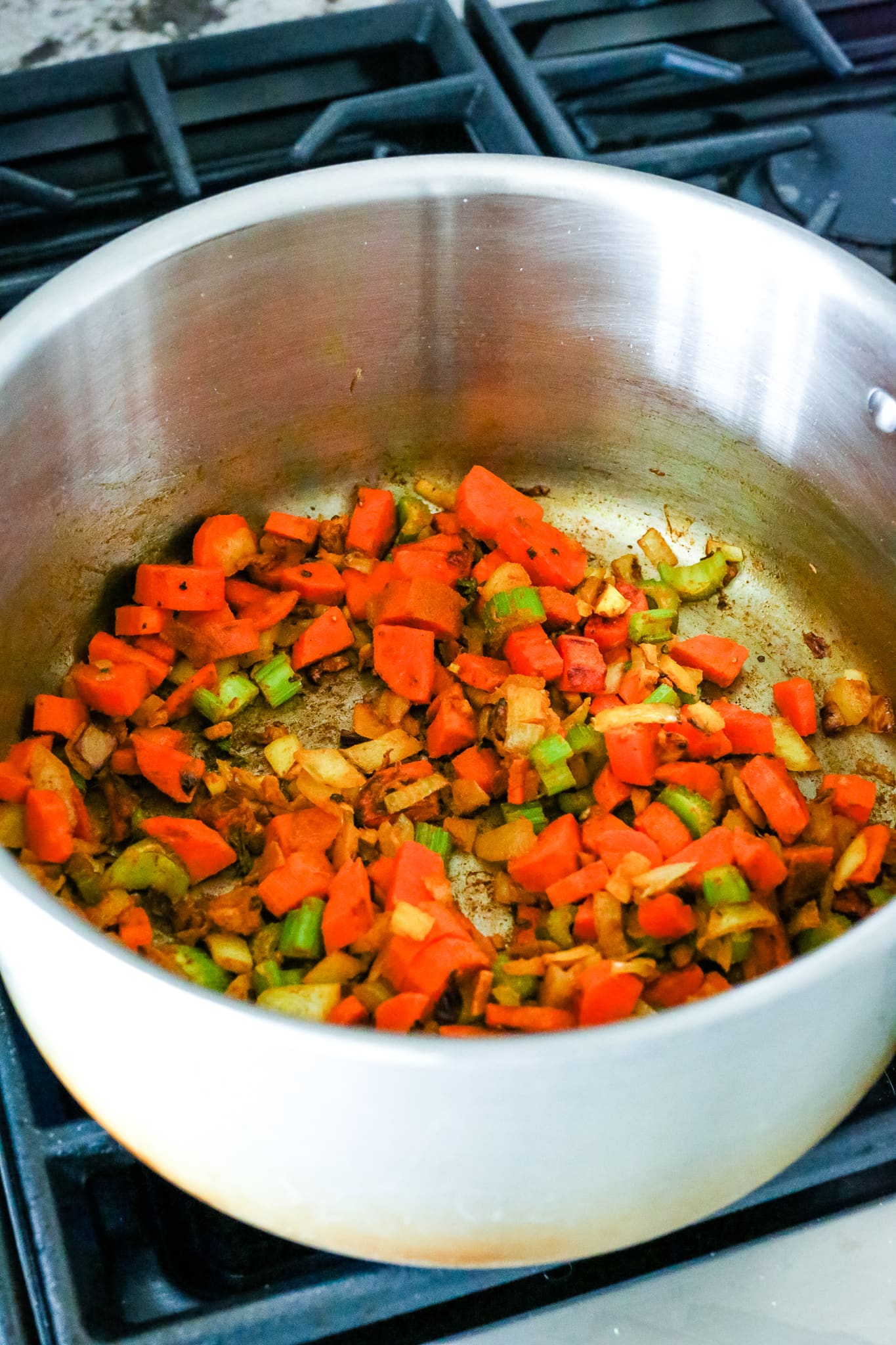 sauteing vegetables in a soup pot on the stovetop