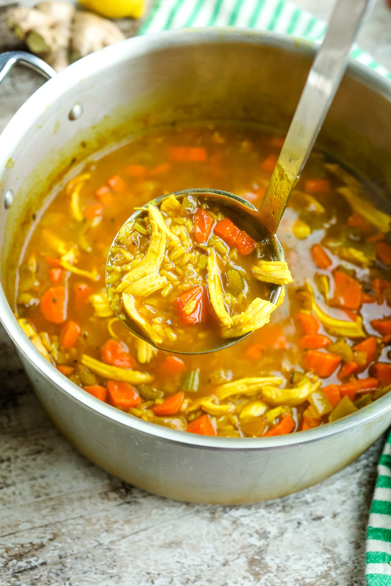 a big pot of soup with a soup ladle scooping out a serving