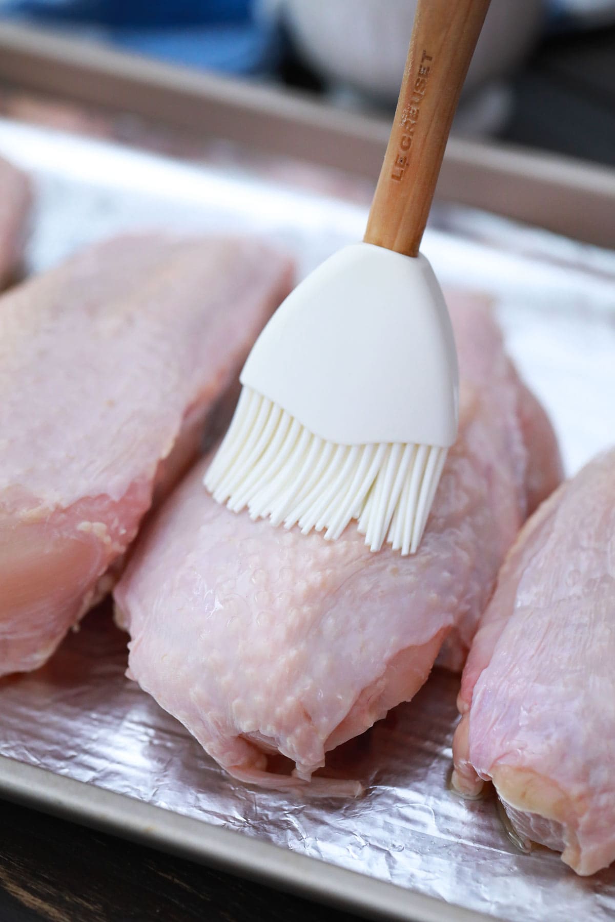 brushing chicken breasts with oil