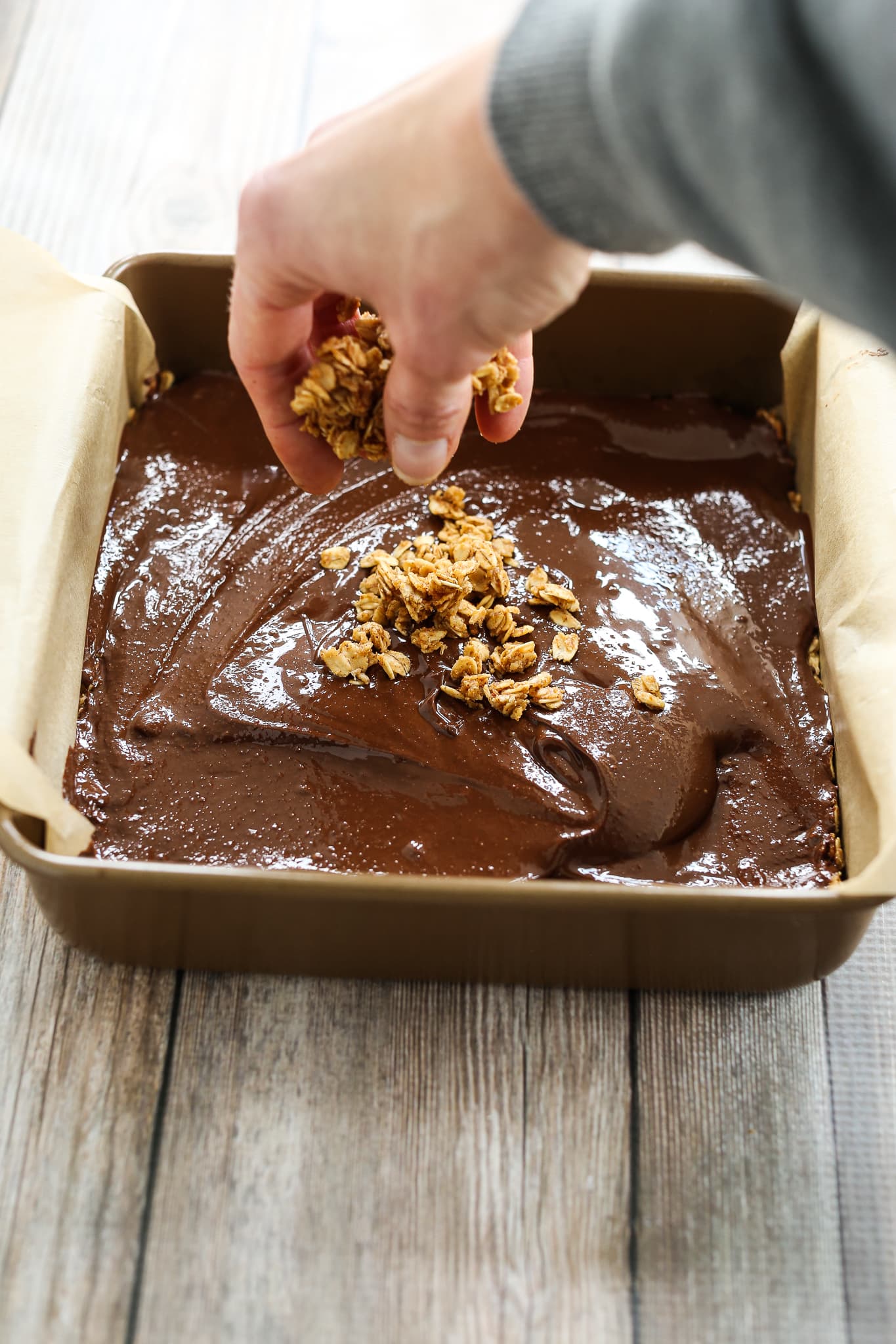 sprinkling oats on top of chocolate