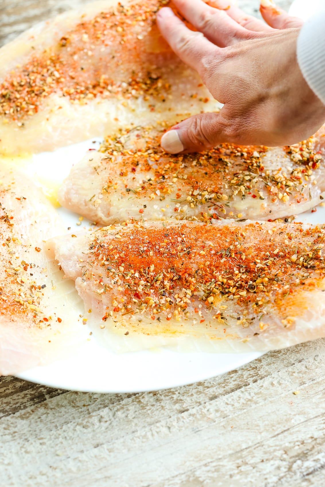 seasoning white fish on a plate