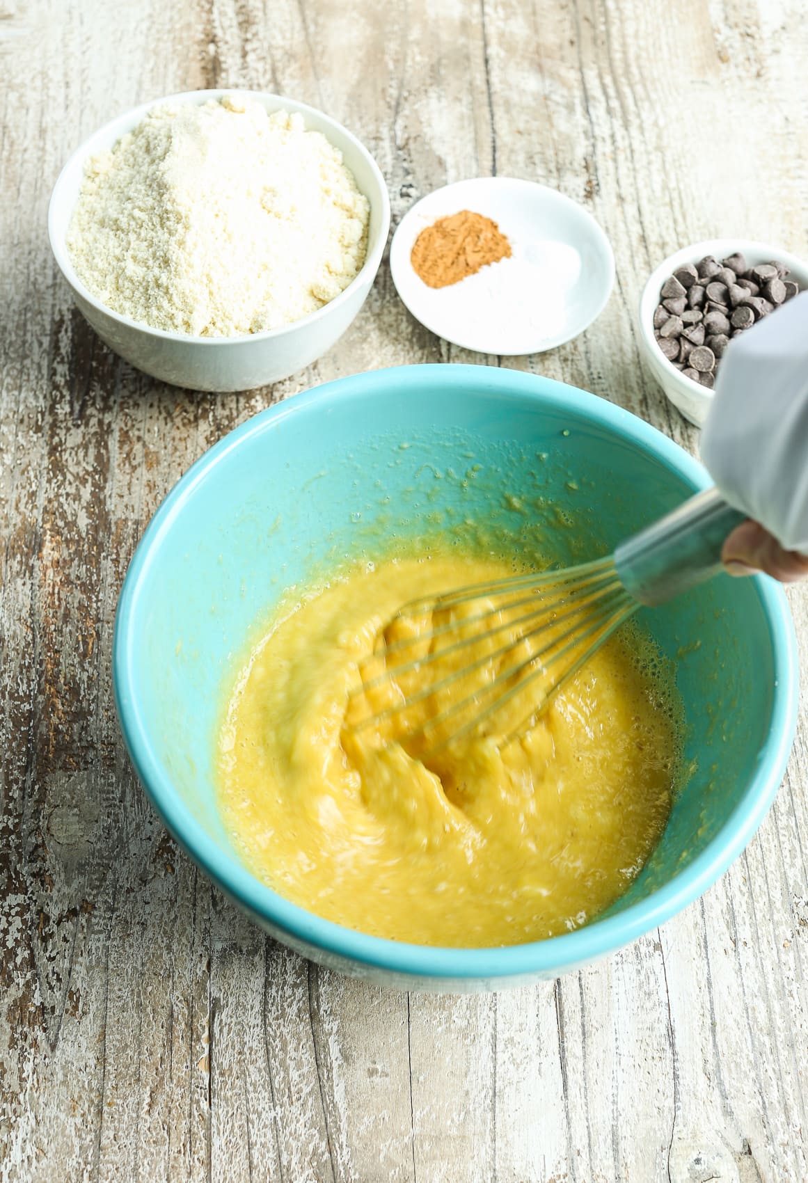 whisking wet ingredients together in a turquoise bowl