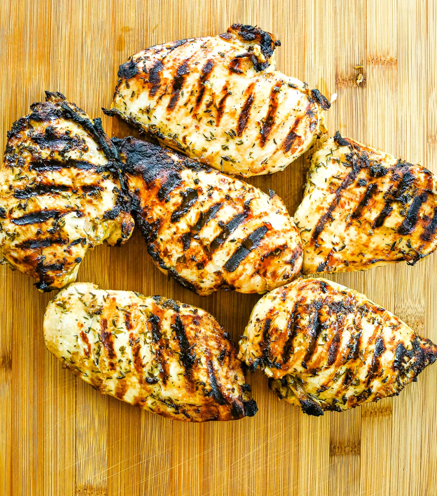 6 chicken breasts with grill marks on a cutting board