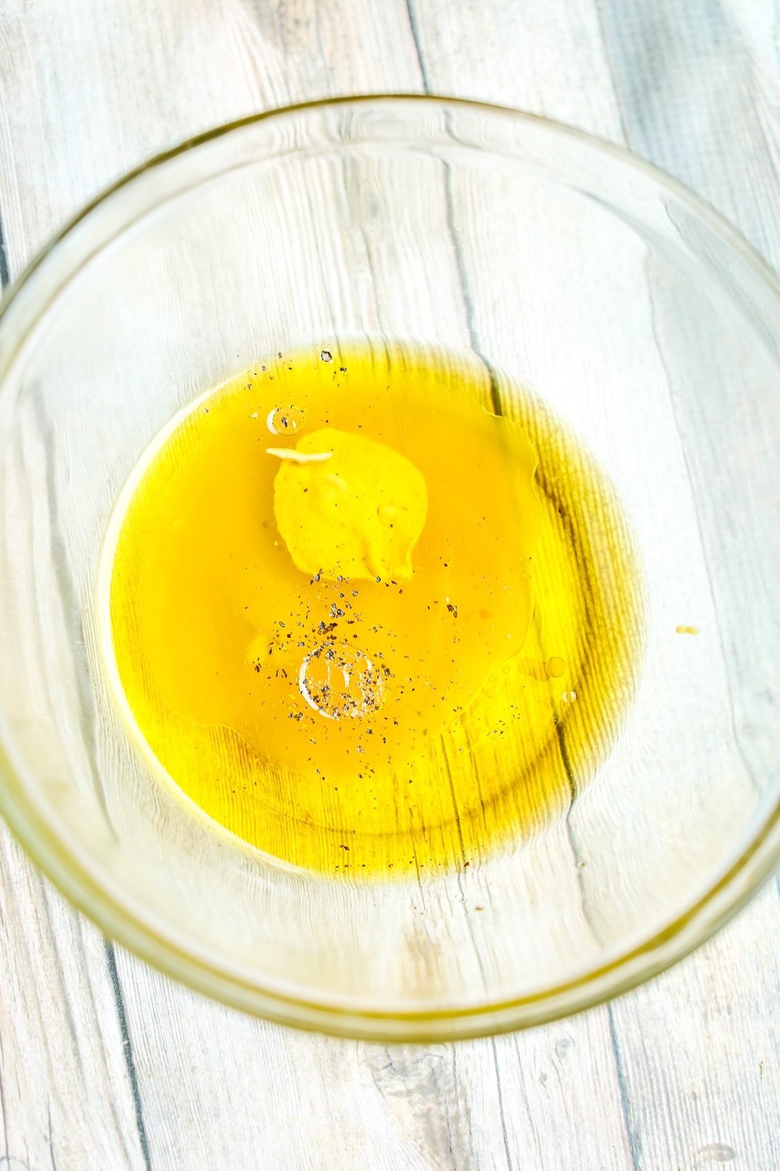 dressing ingredients not mixed together in a glass bowl