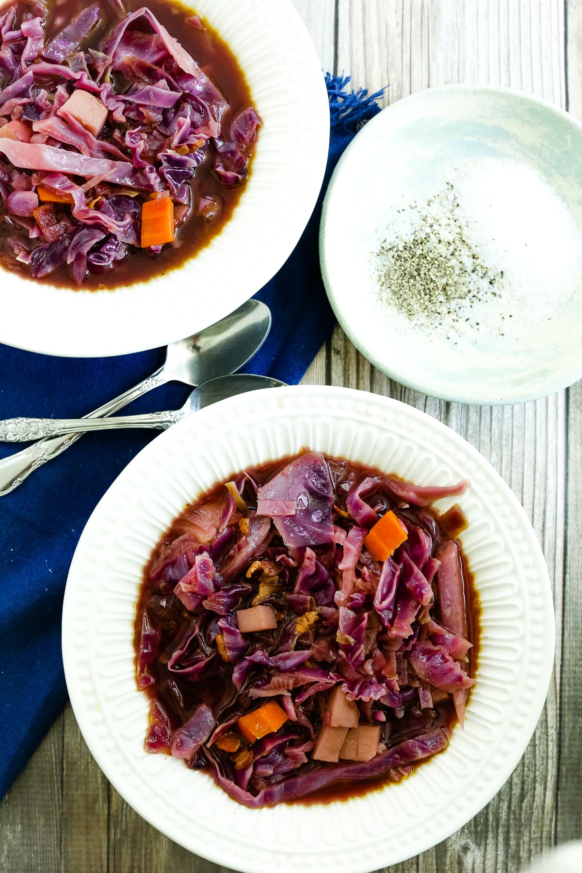 two bowls of Red Cabbage Soup and a small plate of salt and pepper