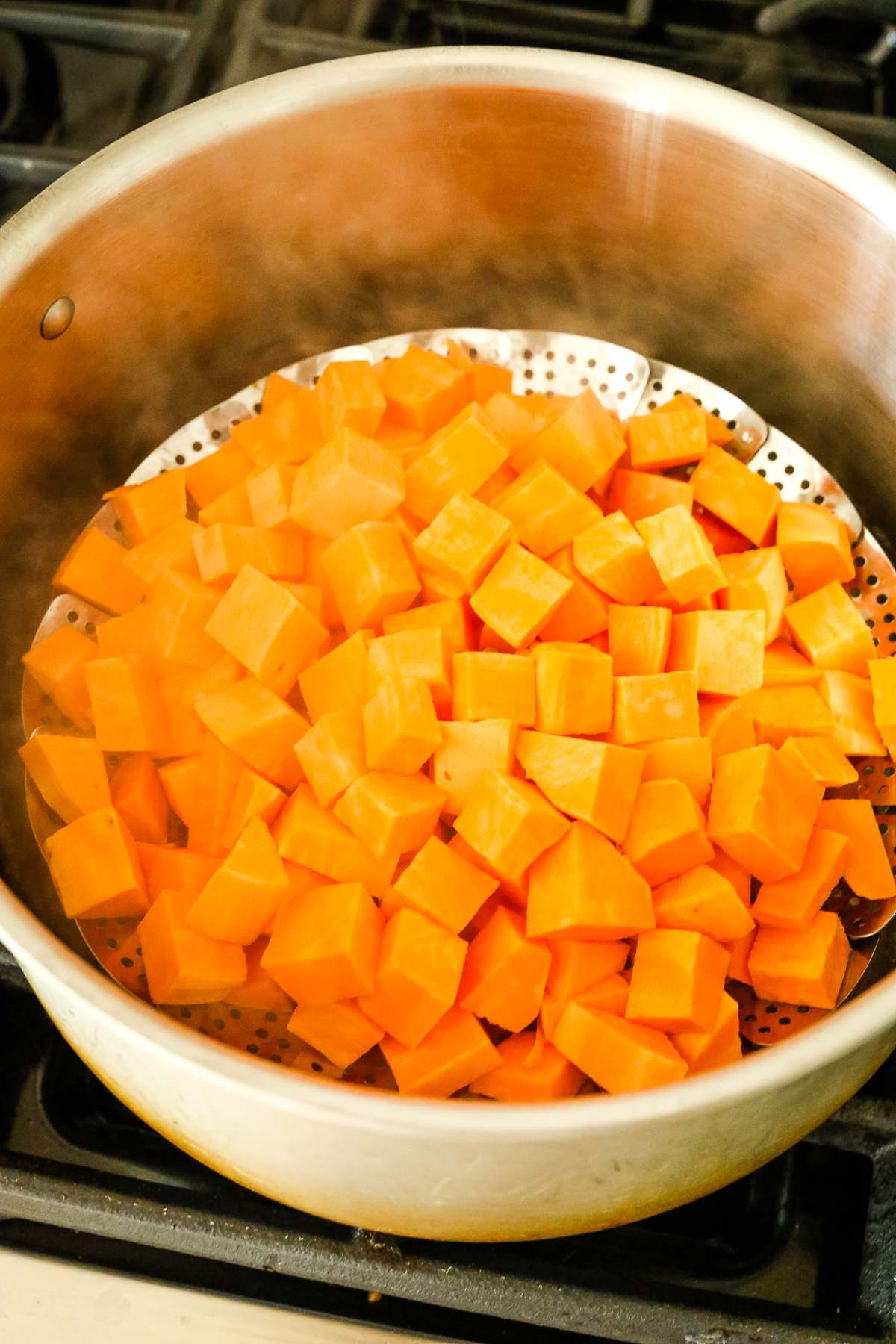 cubed sweet potatoes in a steamer basket