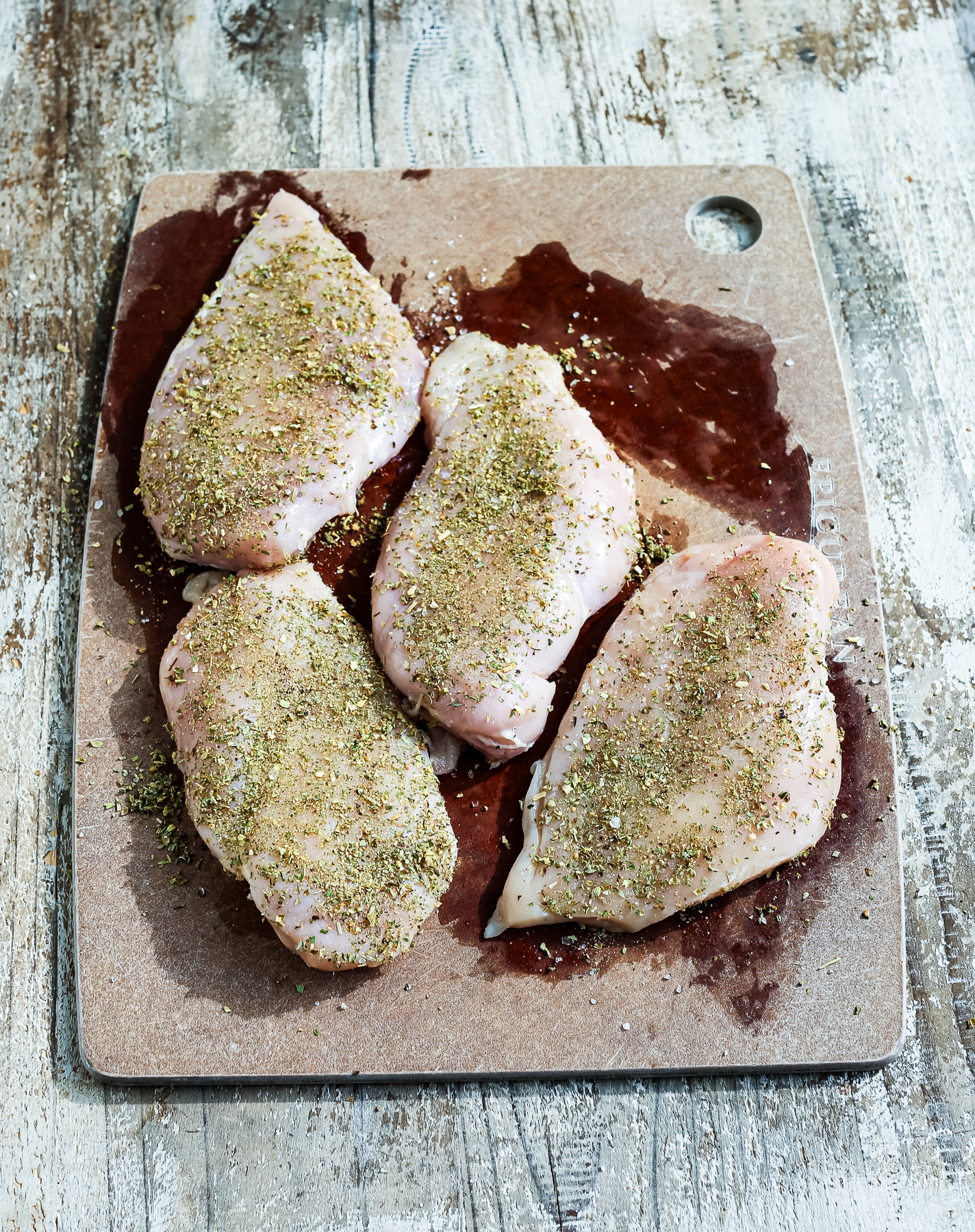 chicken breasts seasoned on a cutting board
