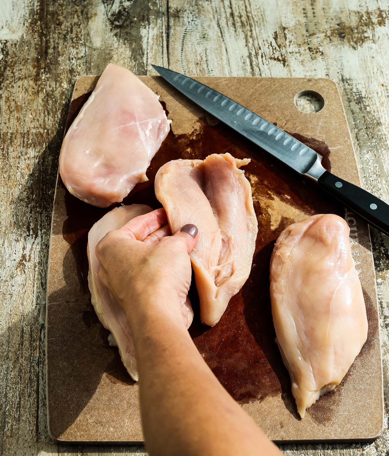 cutting a slice into a chicken breast to create a pcoket