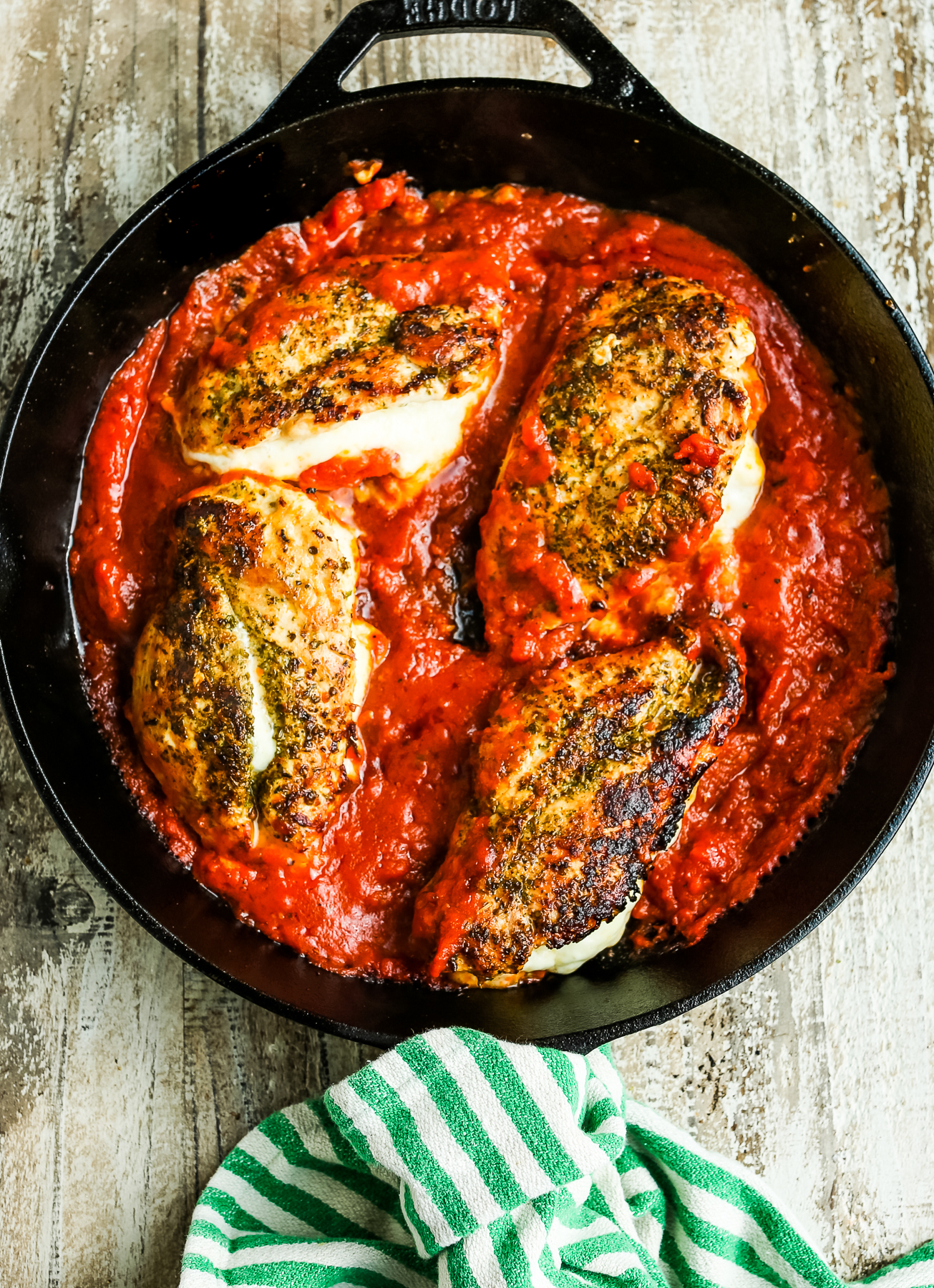 mozzarella stuffed chicken in a pan with marinara sauce
