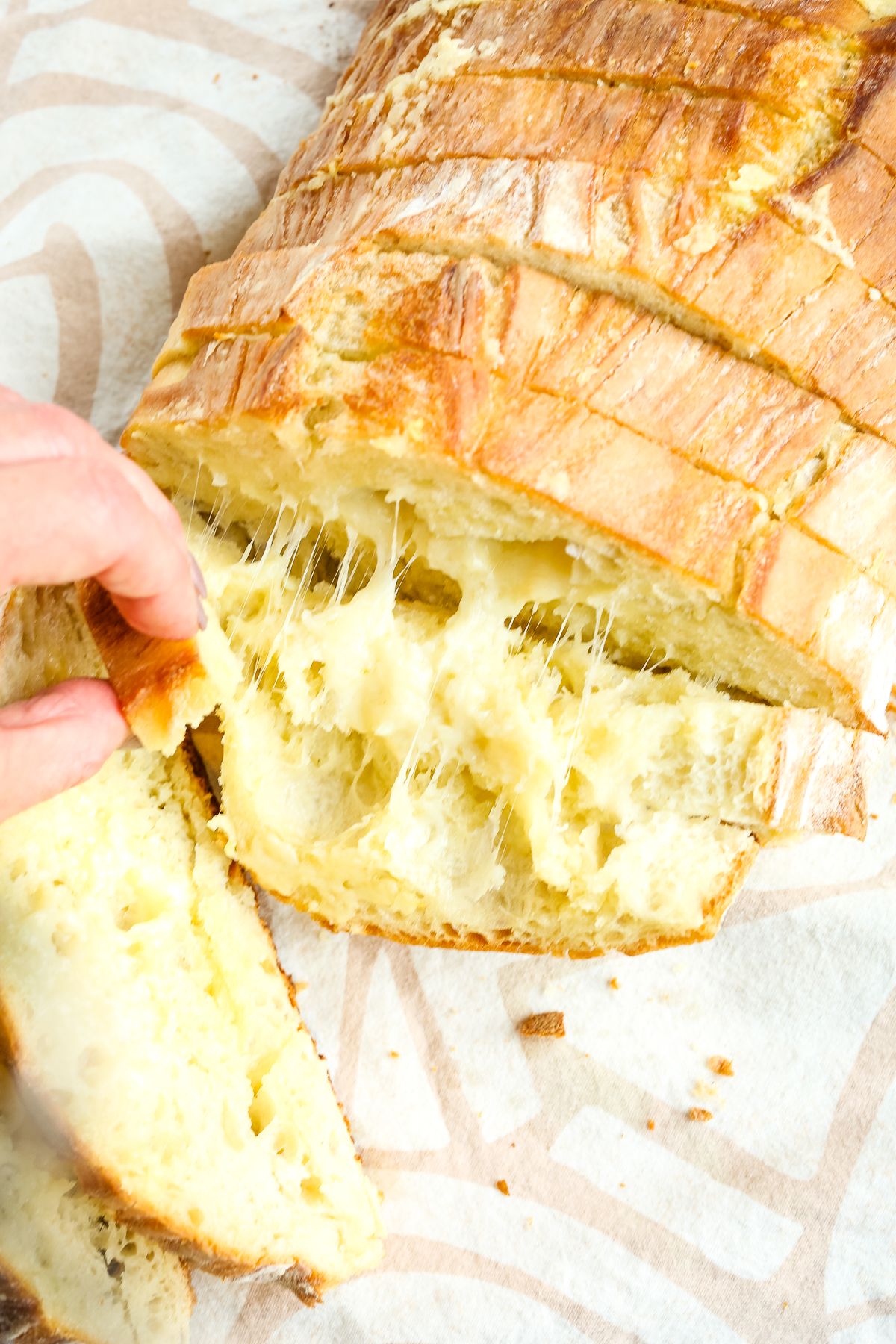 cheesy garlic bread being pulled away from the loaf