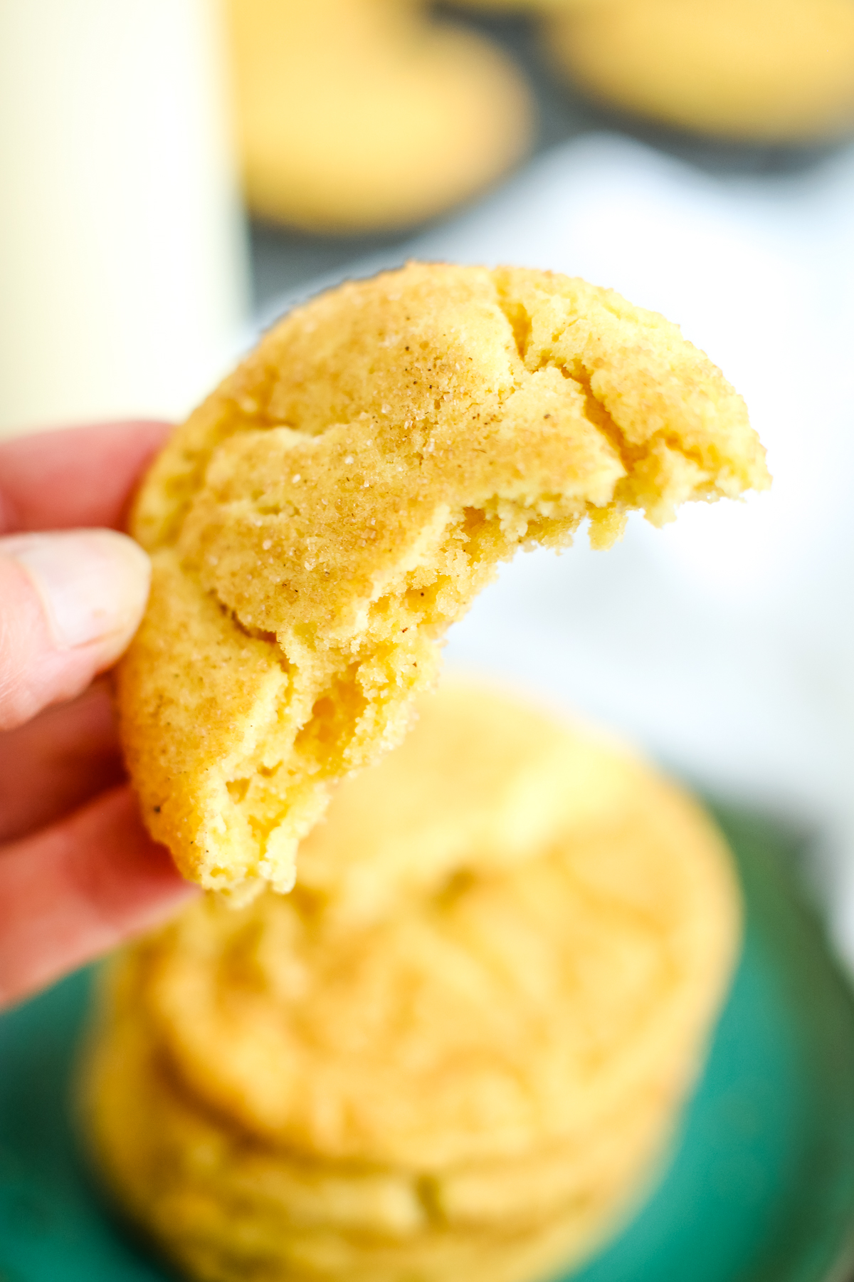 a bite out of a cookie being held close to camera to show soft texture of cookie