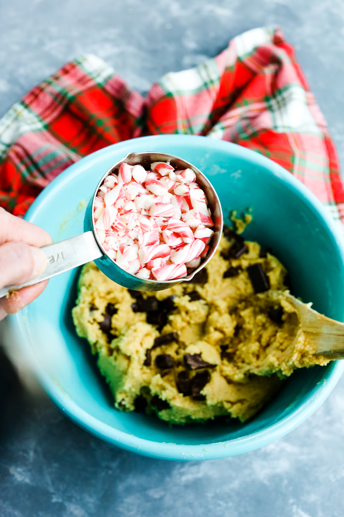 chocolate chip cookie dough with a cup of candy cane pieces