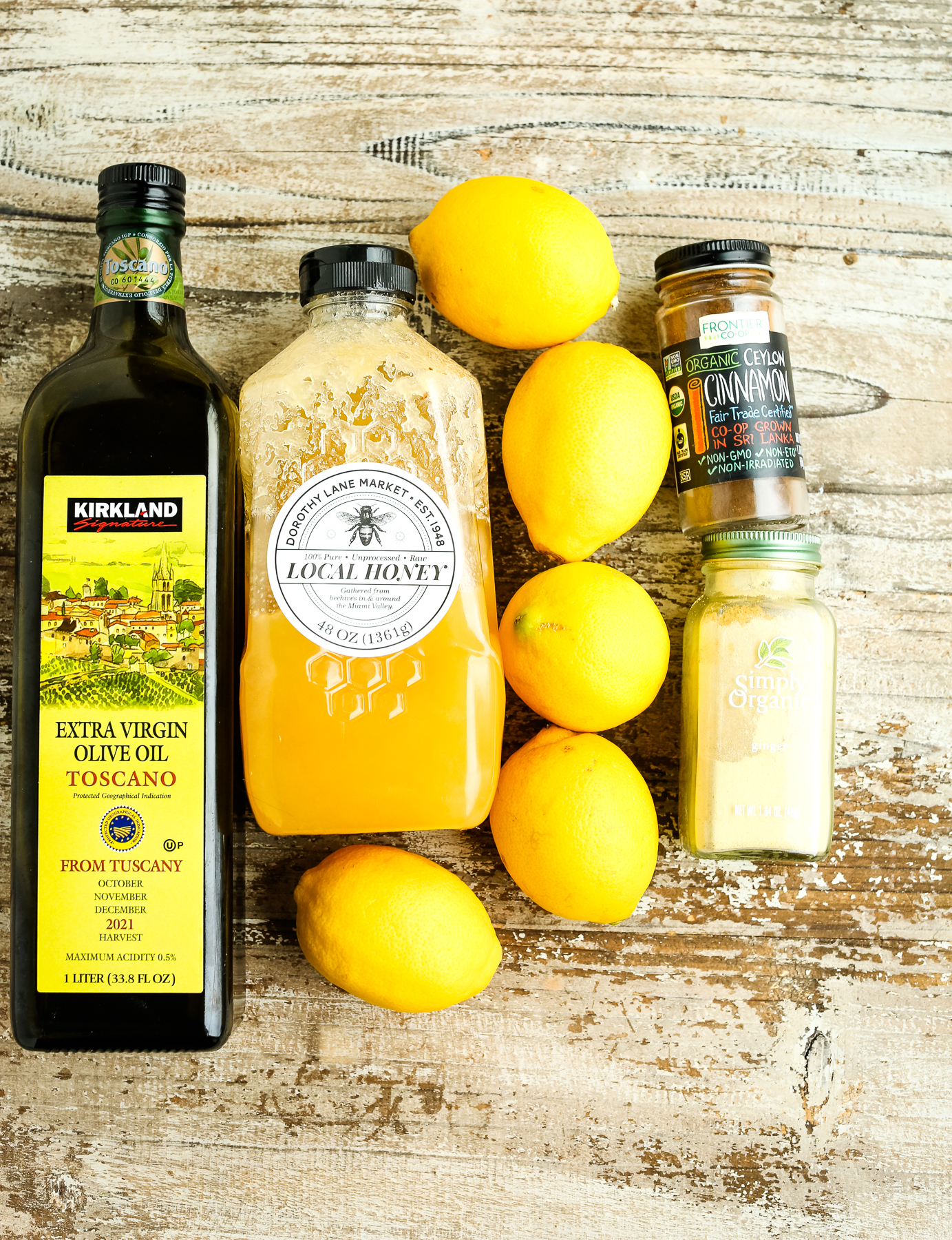 olive oil, honey, lemons, ground cinnamon and ground ginger on a board