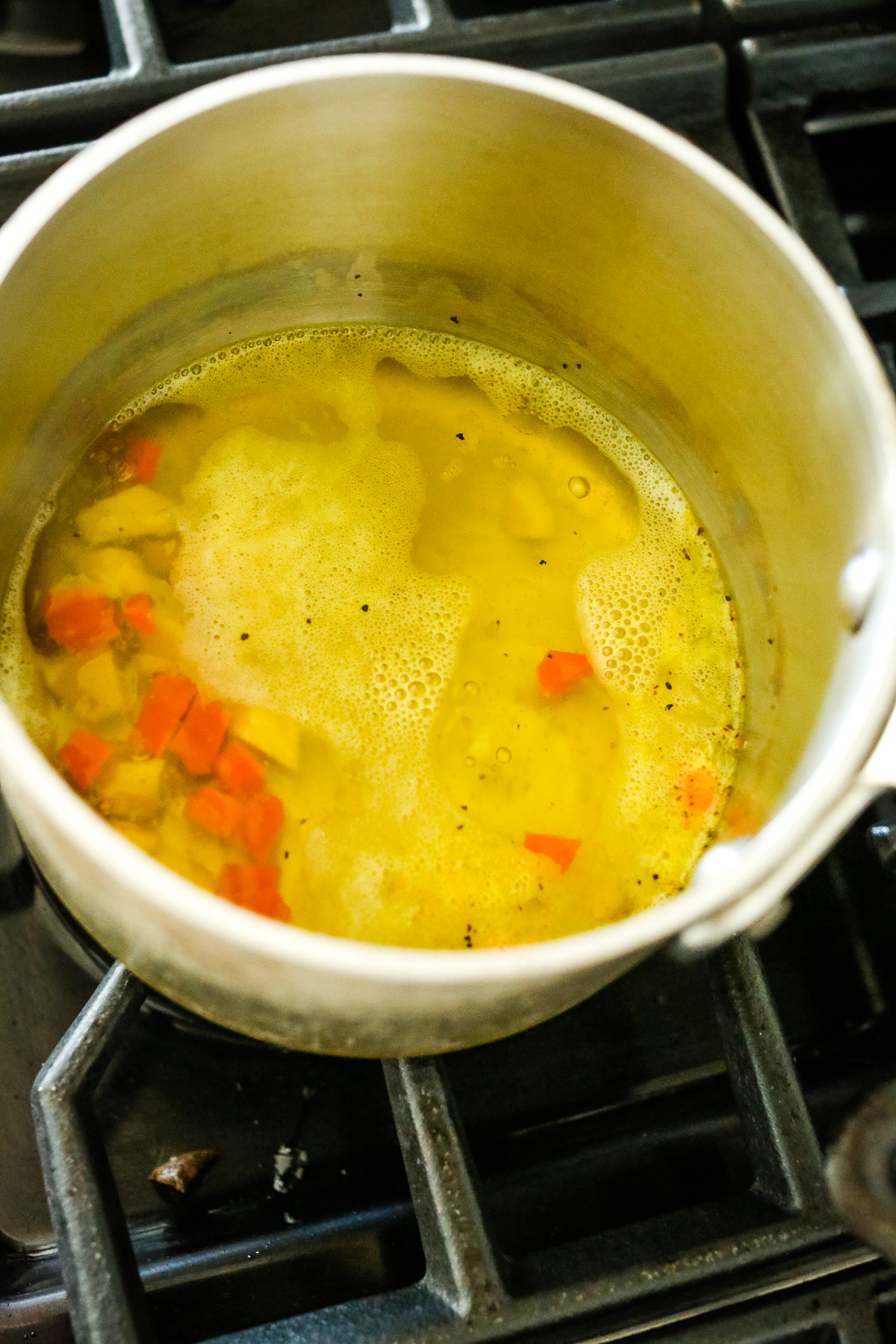 simmering liquid with turmeric and ginger