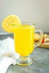 Lemon Ginger Turmeric Tea in a clear mug with a lemon wheel on the rim