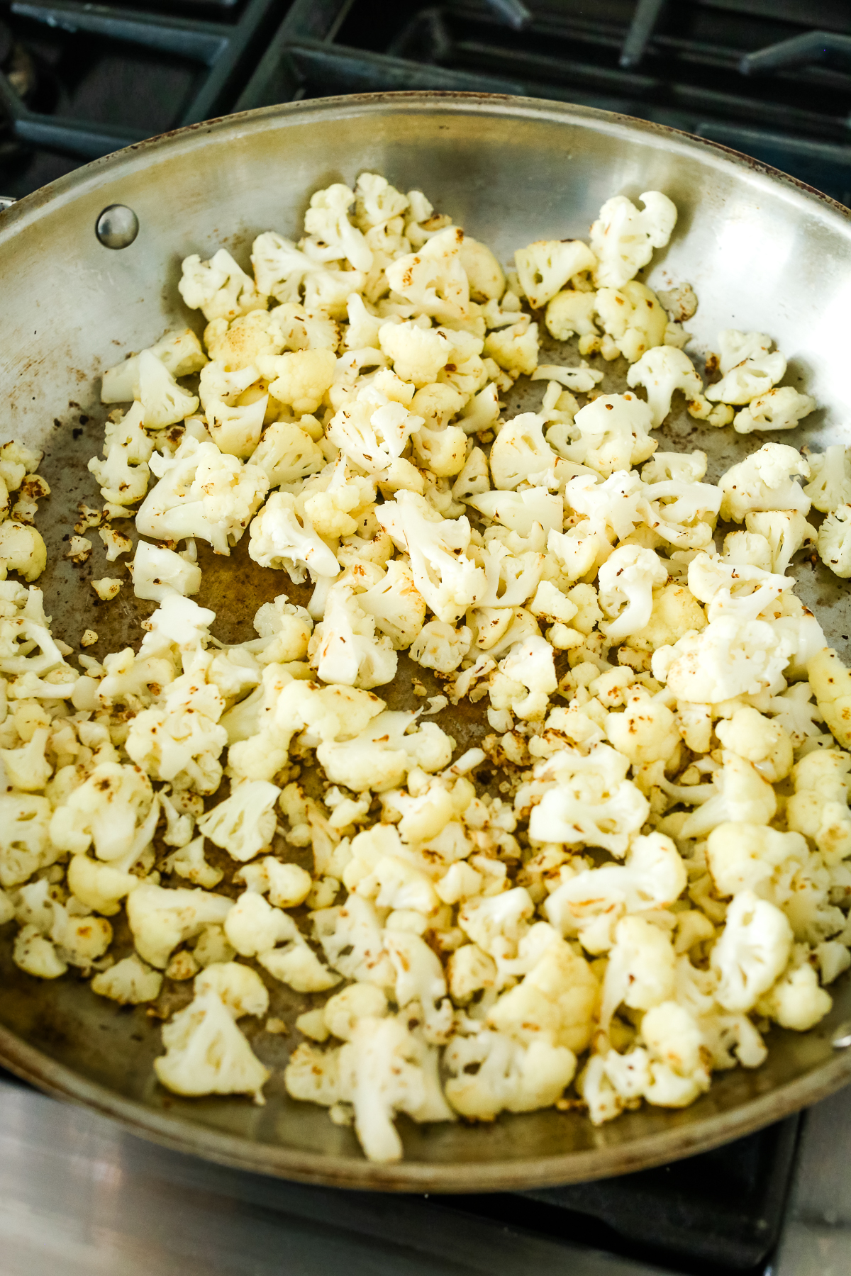 cauliflower pieces cooking in a large pan