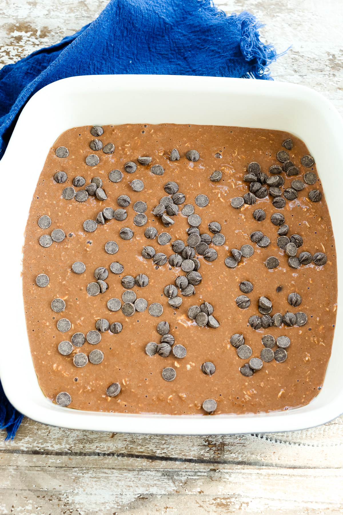 chocolately batter with chocolate chips on top in a baking pan