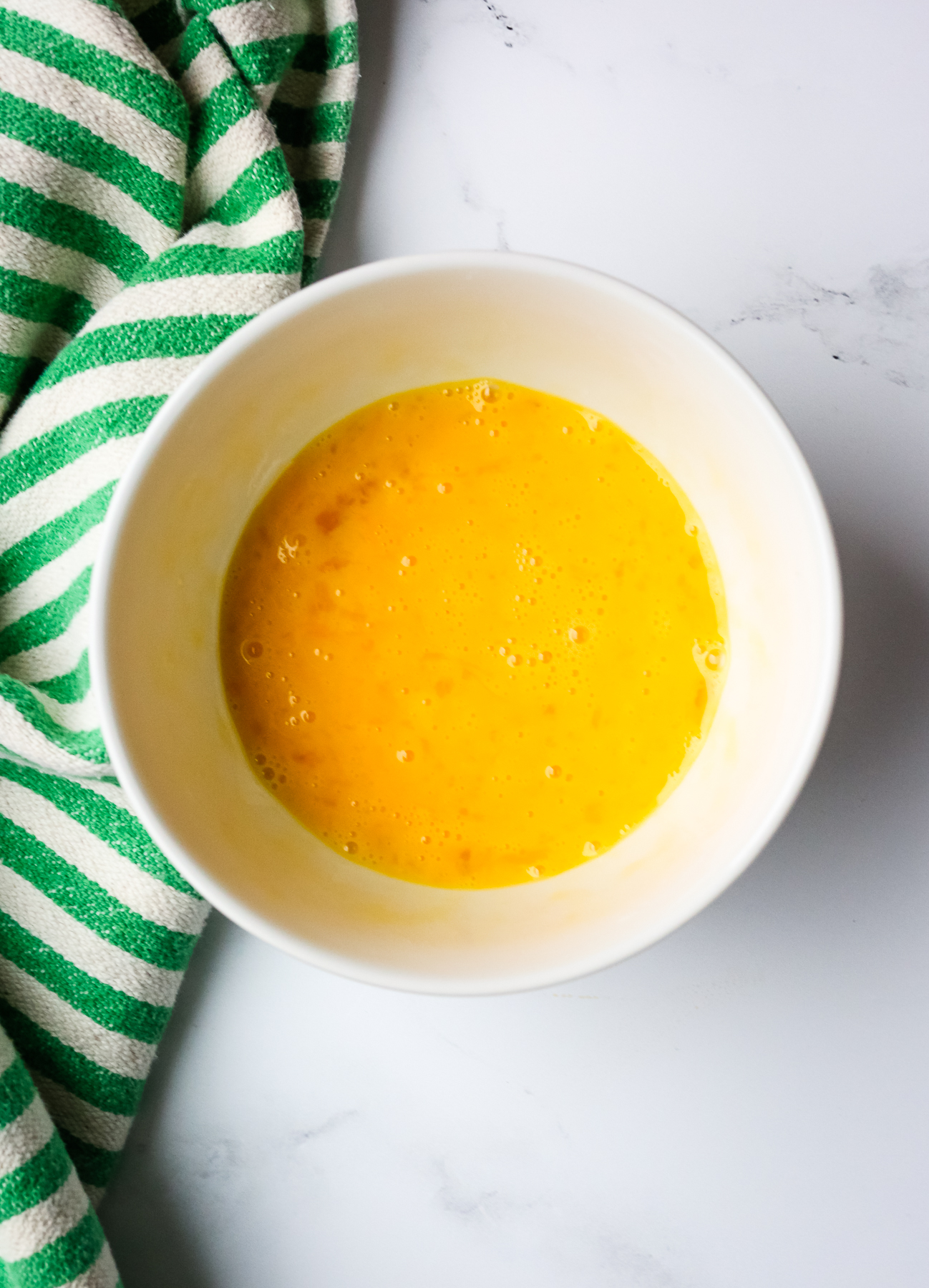 whisked eggs in a white bowl