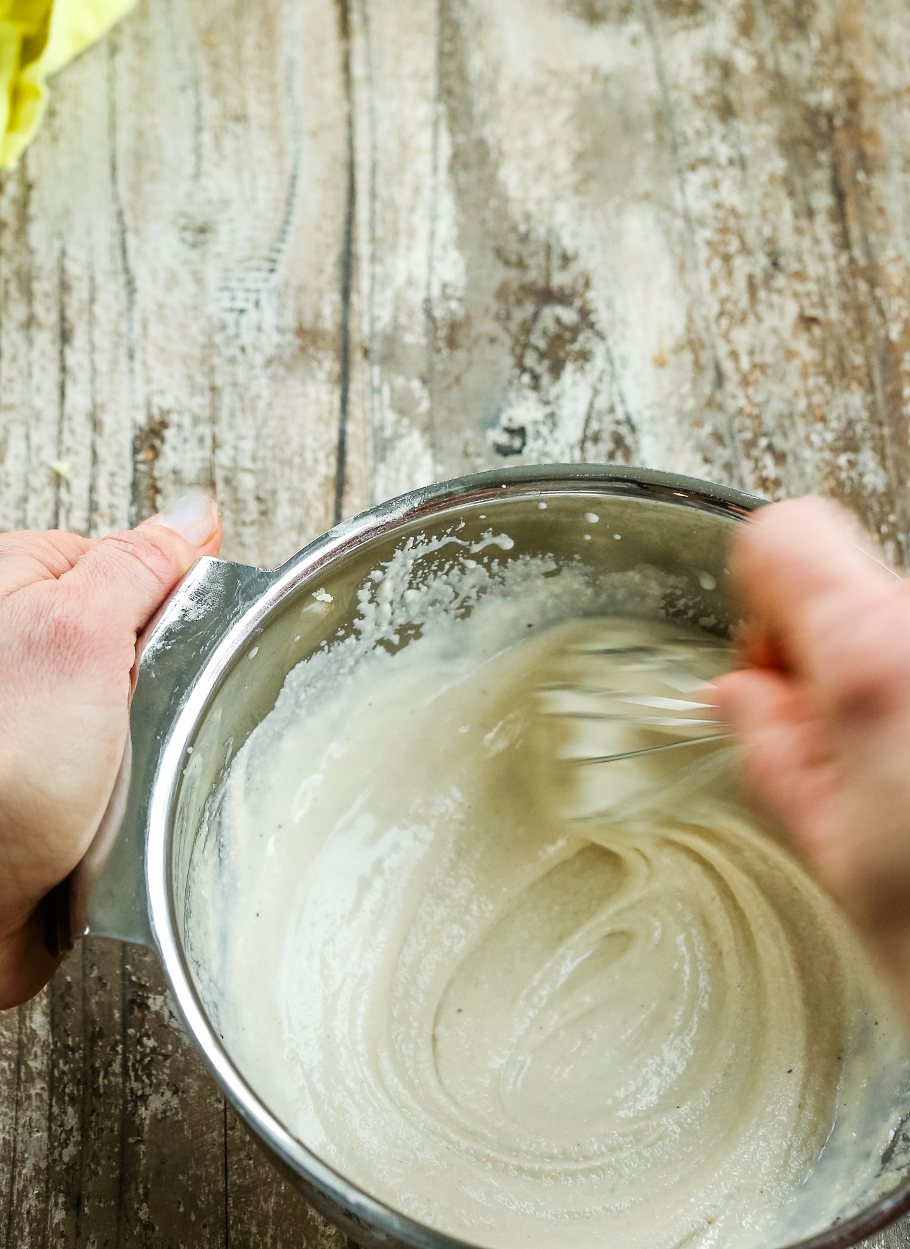 whisking garlic tahini sauce in a bowl