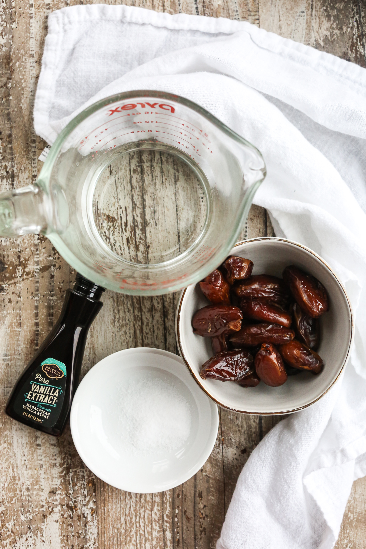 overhead shot of dates, salt, vanilla, and water