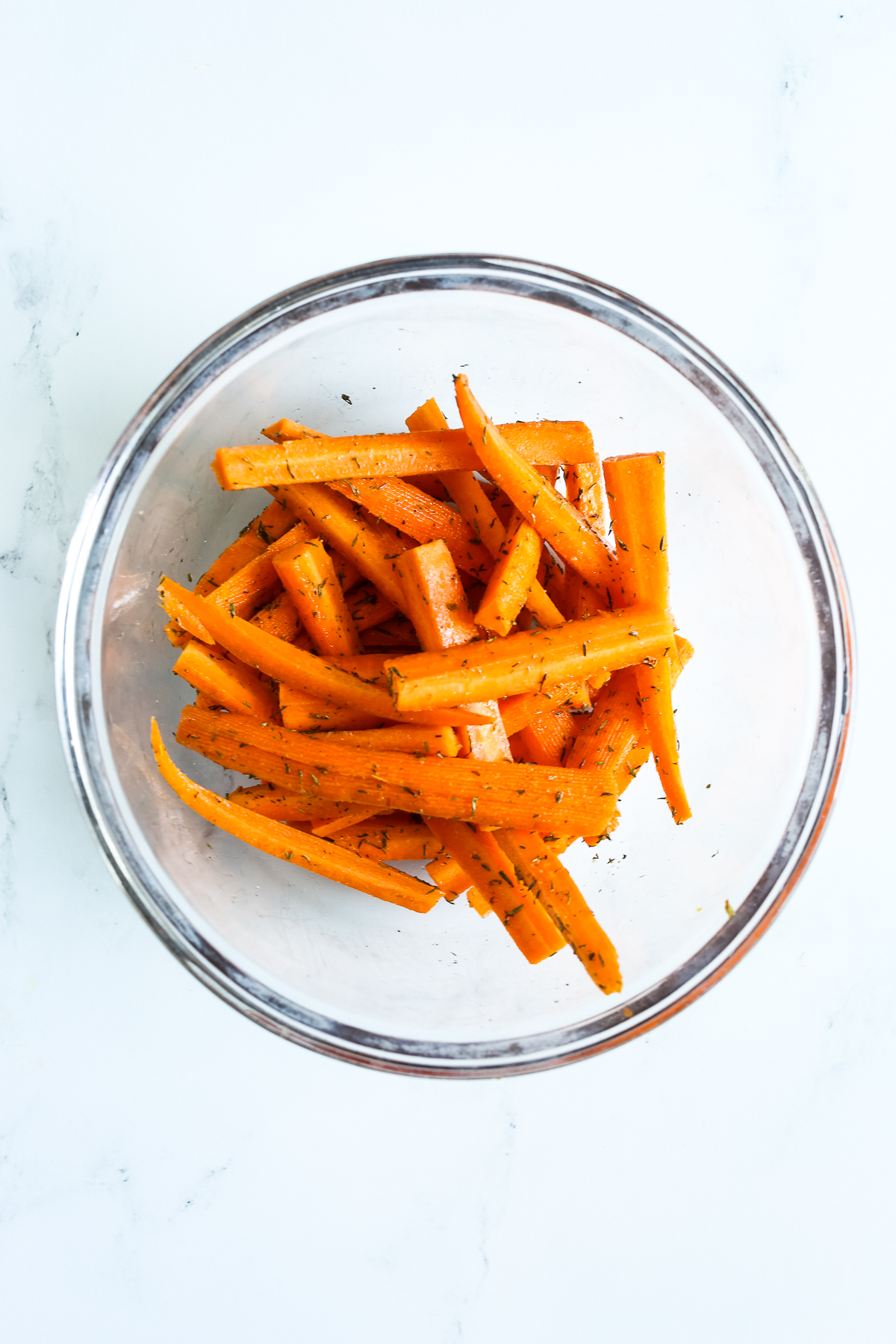 cut carrots in a glass bowl with seasonings
