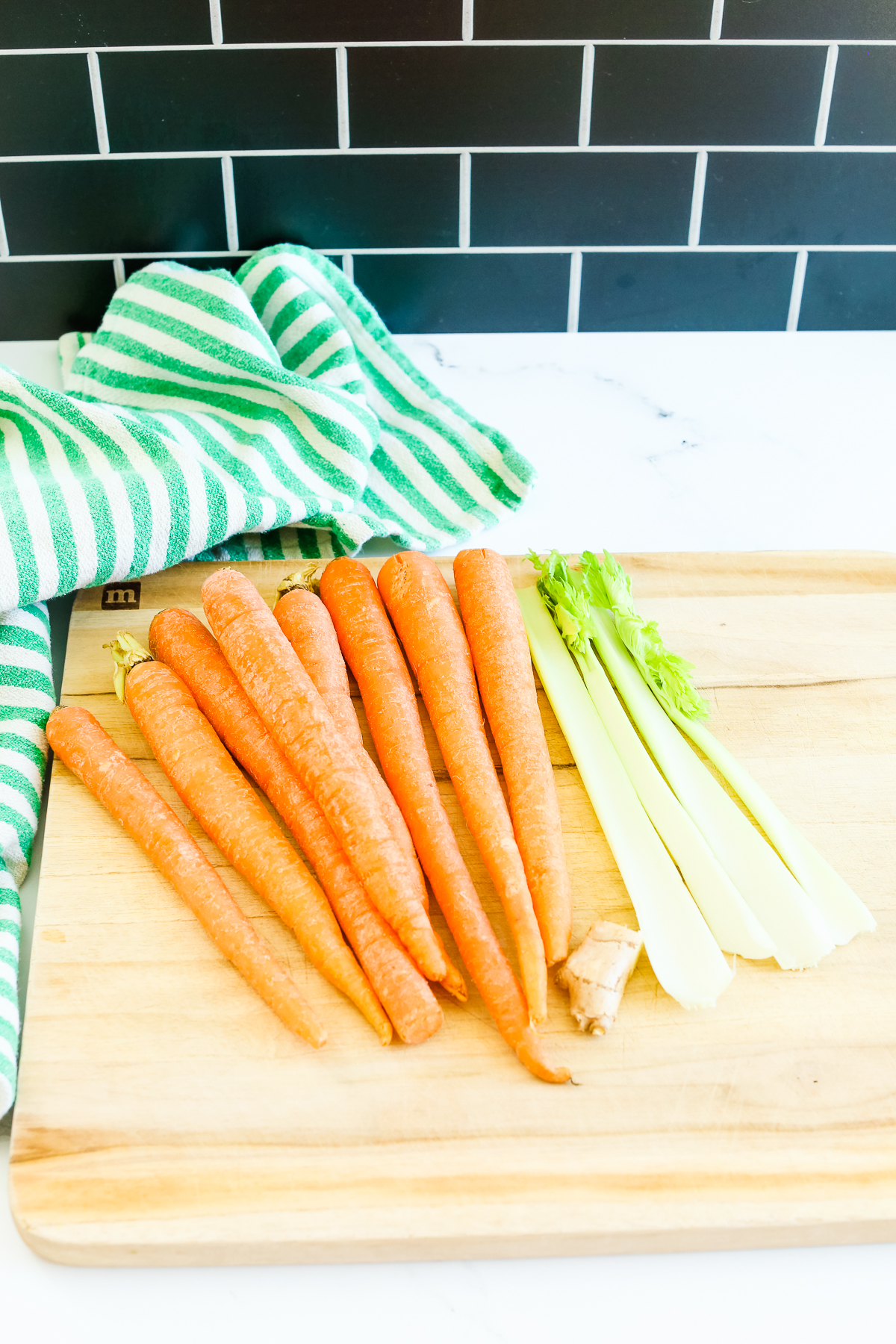 carrots, celery, and ginger on a cutting board