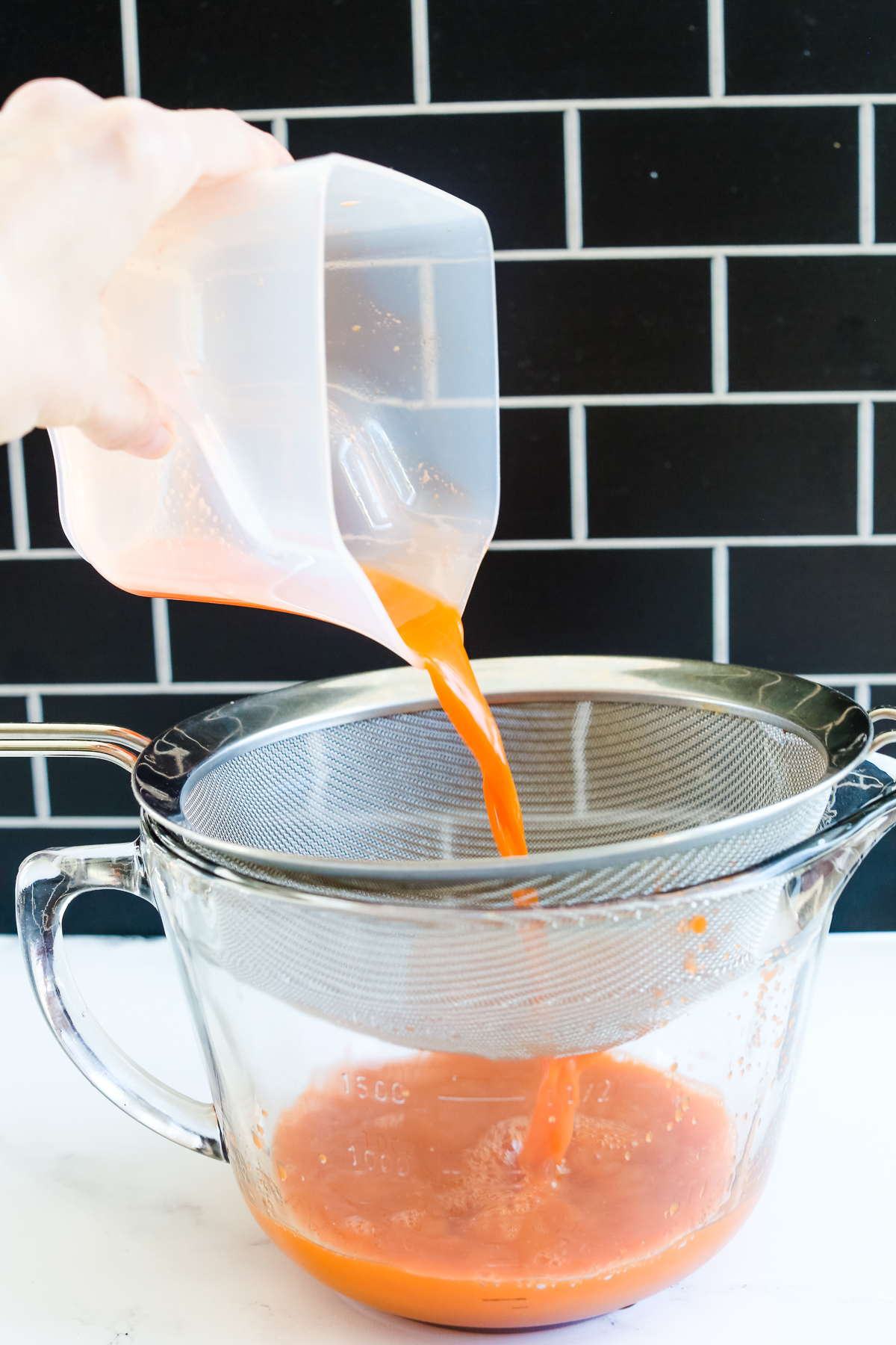 straining juice through a sieve