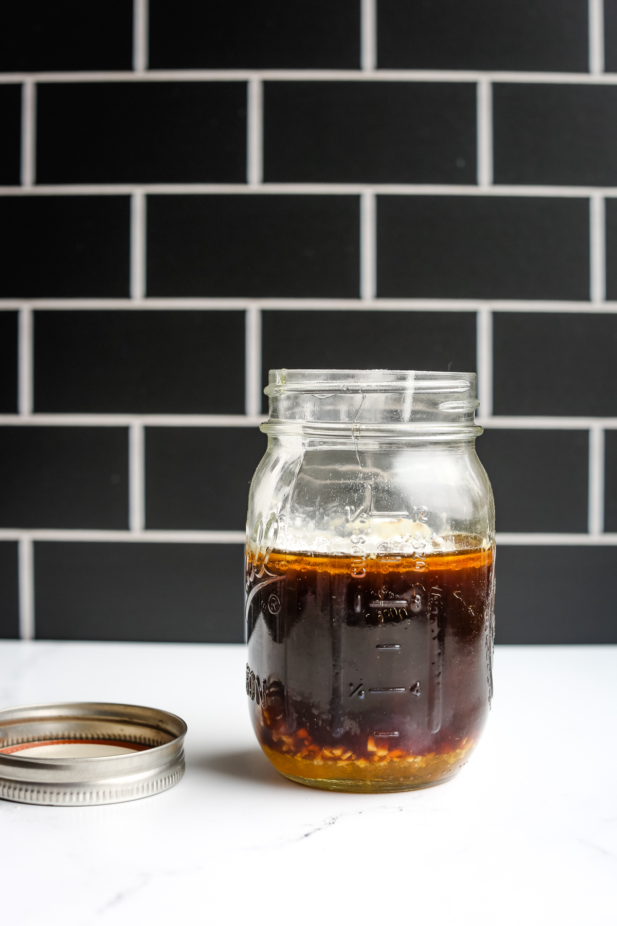 healthy stir fry sauce in a jar with the lid on the table next to it
