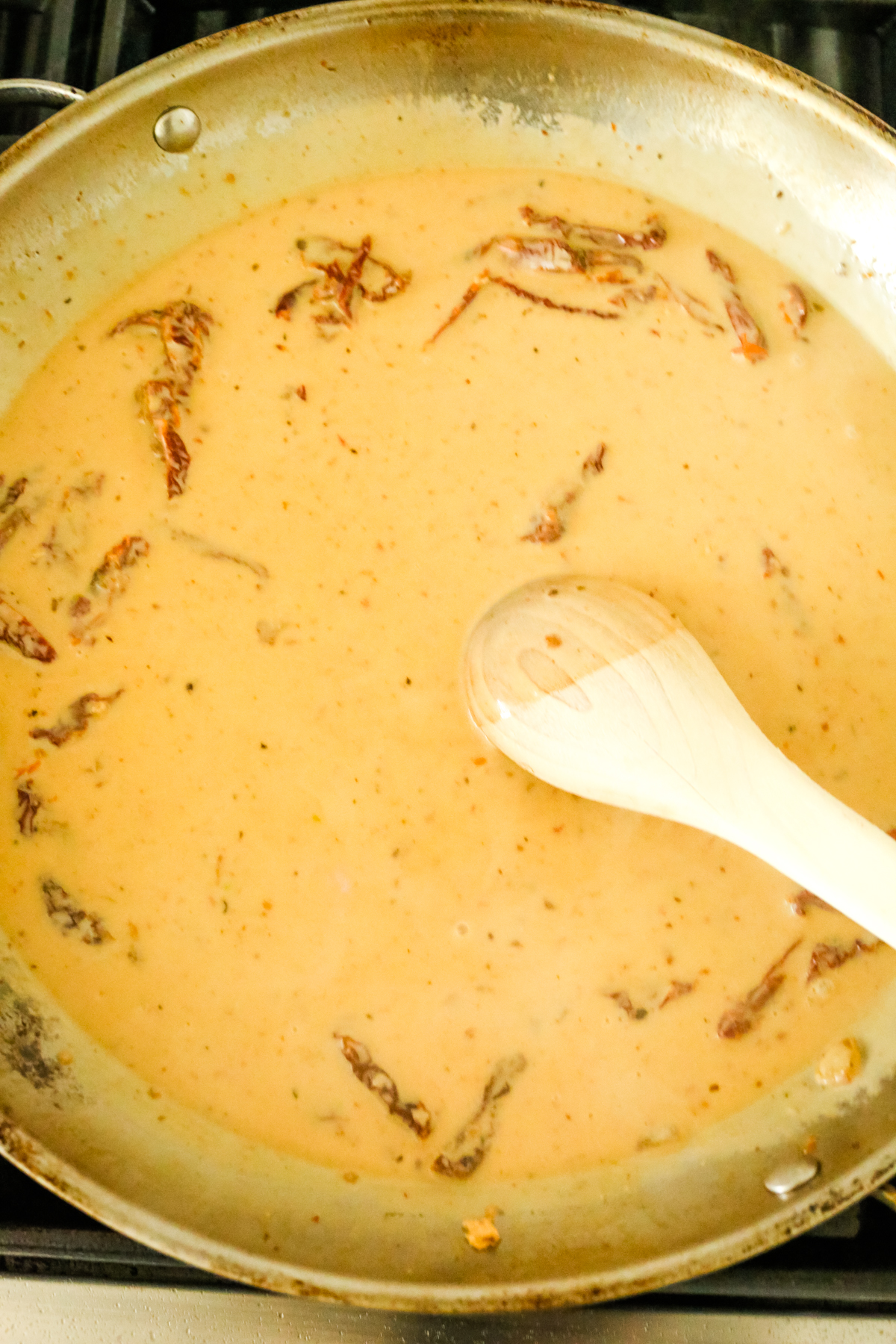 stirring sauce with tomatoes