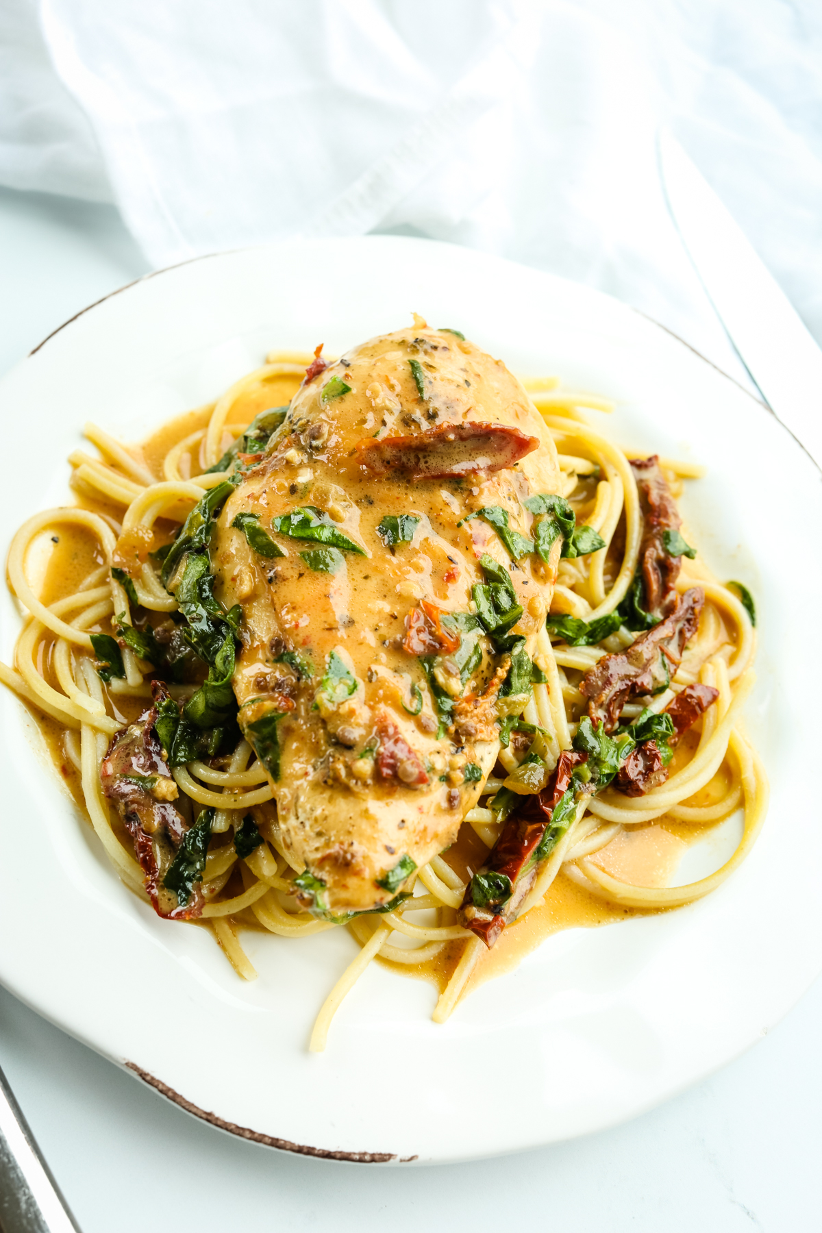 dairy free tuscan chicken with pasta and sauce on a plate