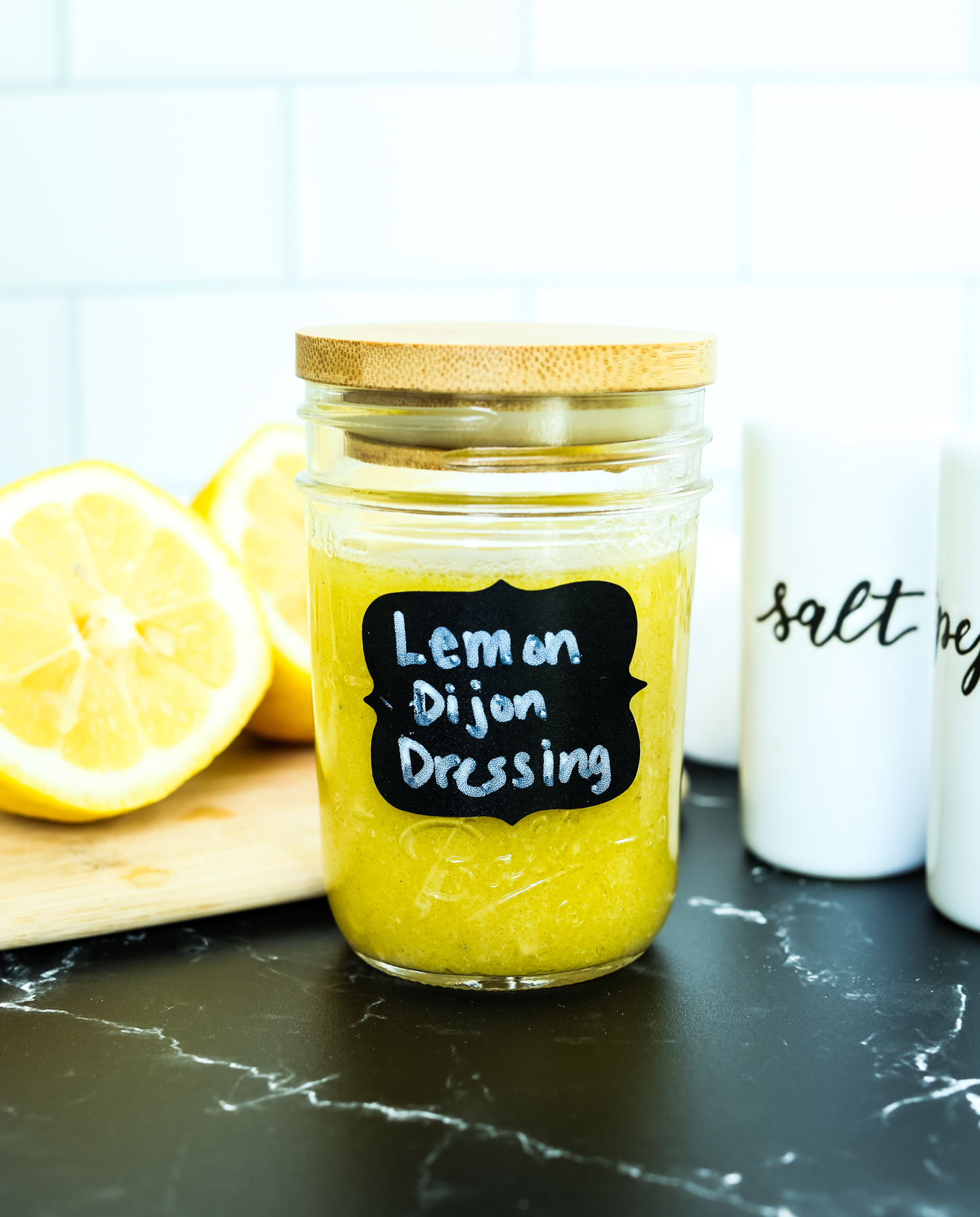 lemon dijon dressing in a jar with a black label