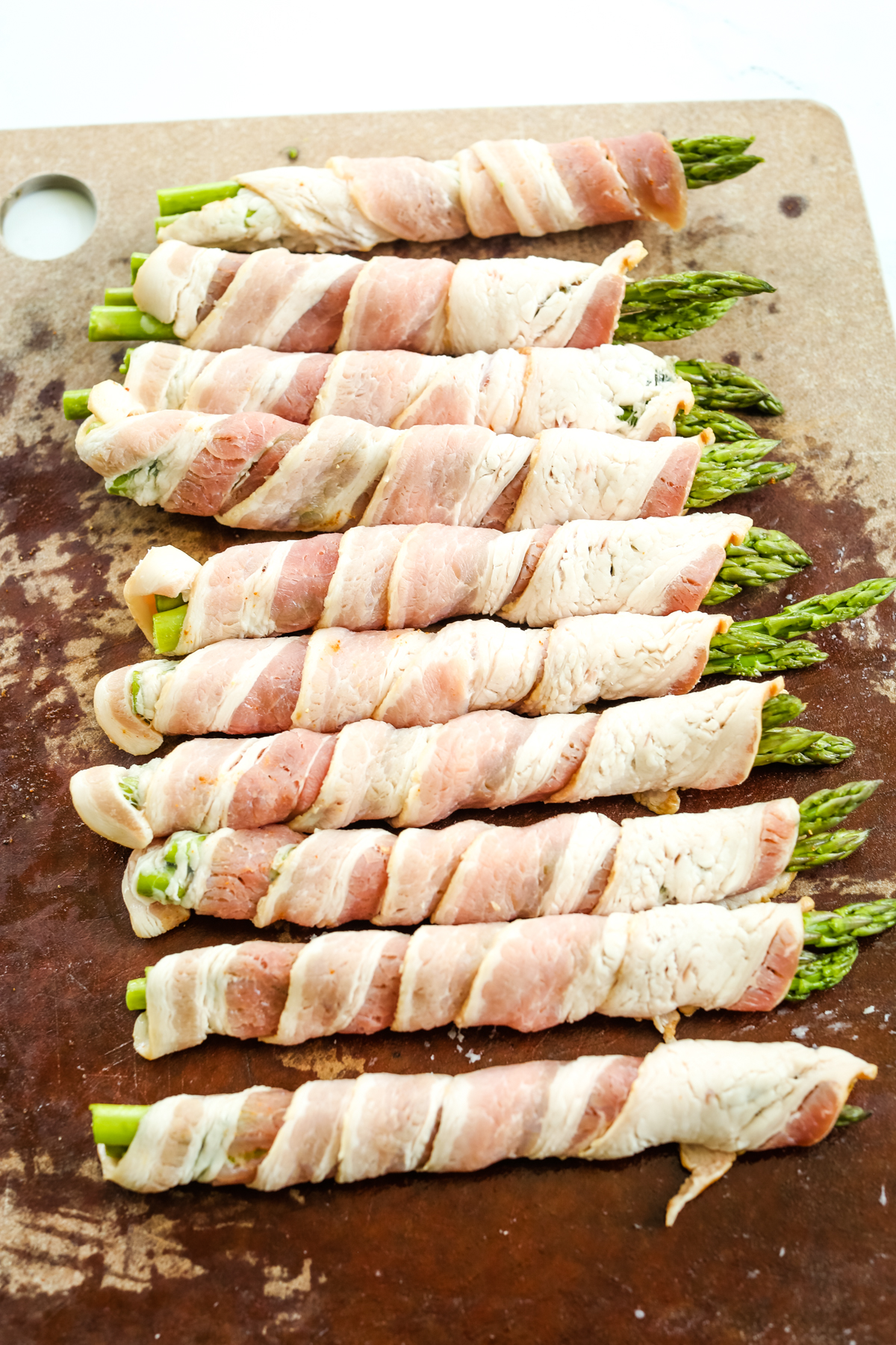 wrapping bacon around 3 asparagus spears