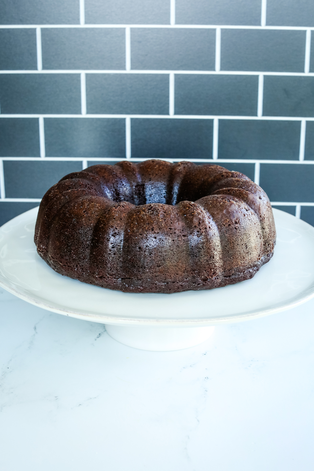 chocolate orange cake on a white cake stand with no frosting or glaze