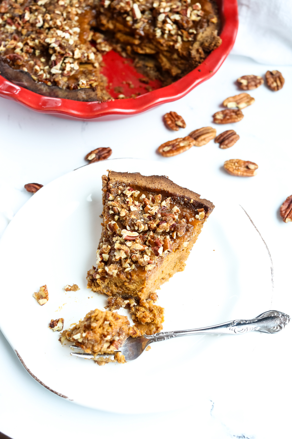 a pie on a white plate with a fork taking a bite