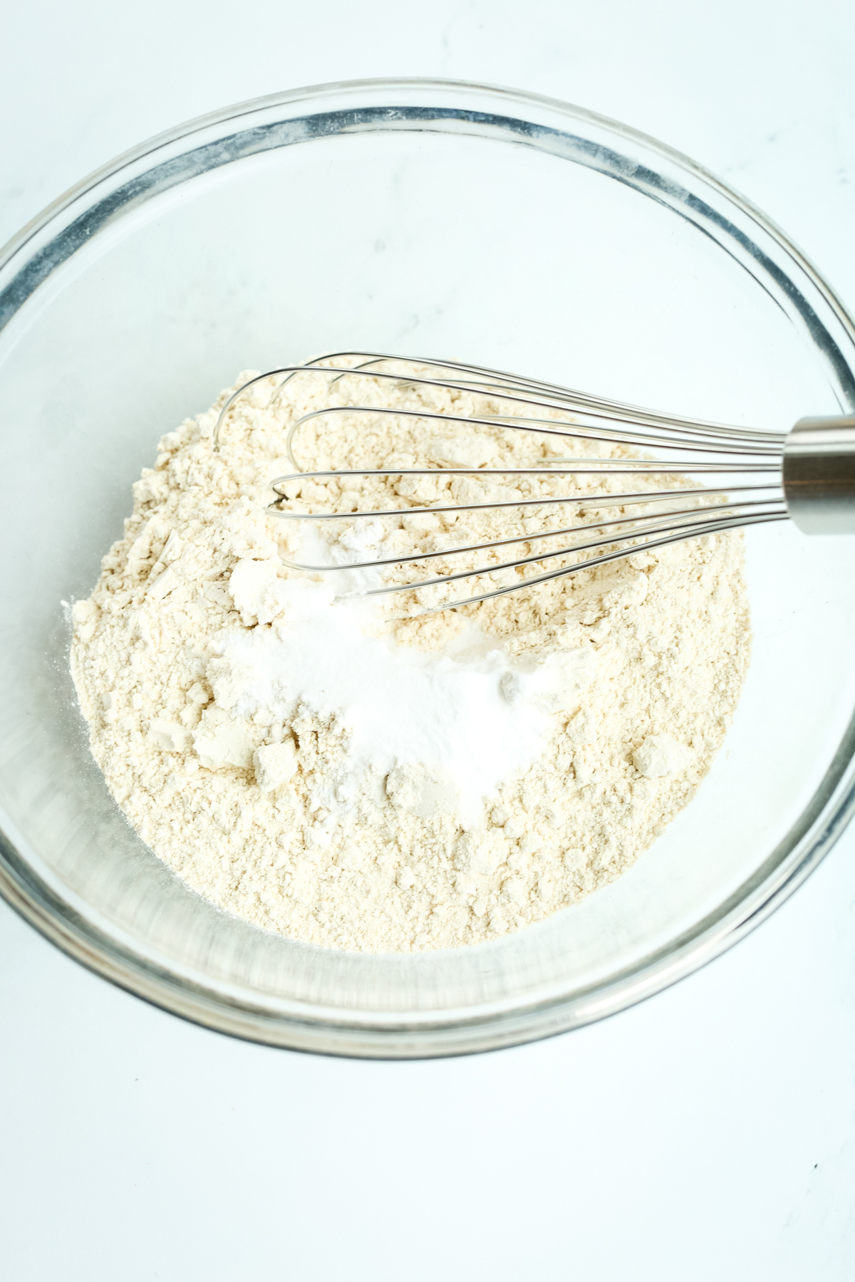 whisking together dry ingredients in a clear glass bowl