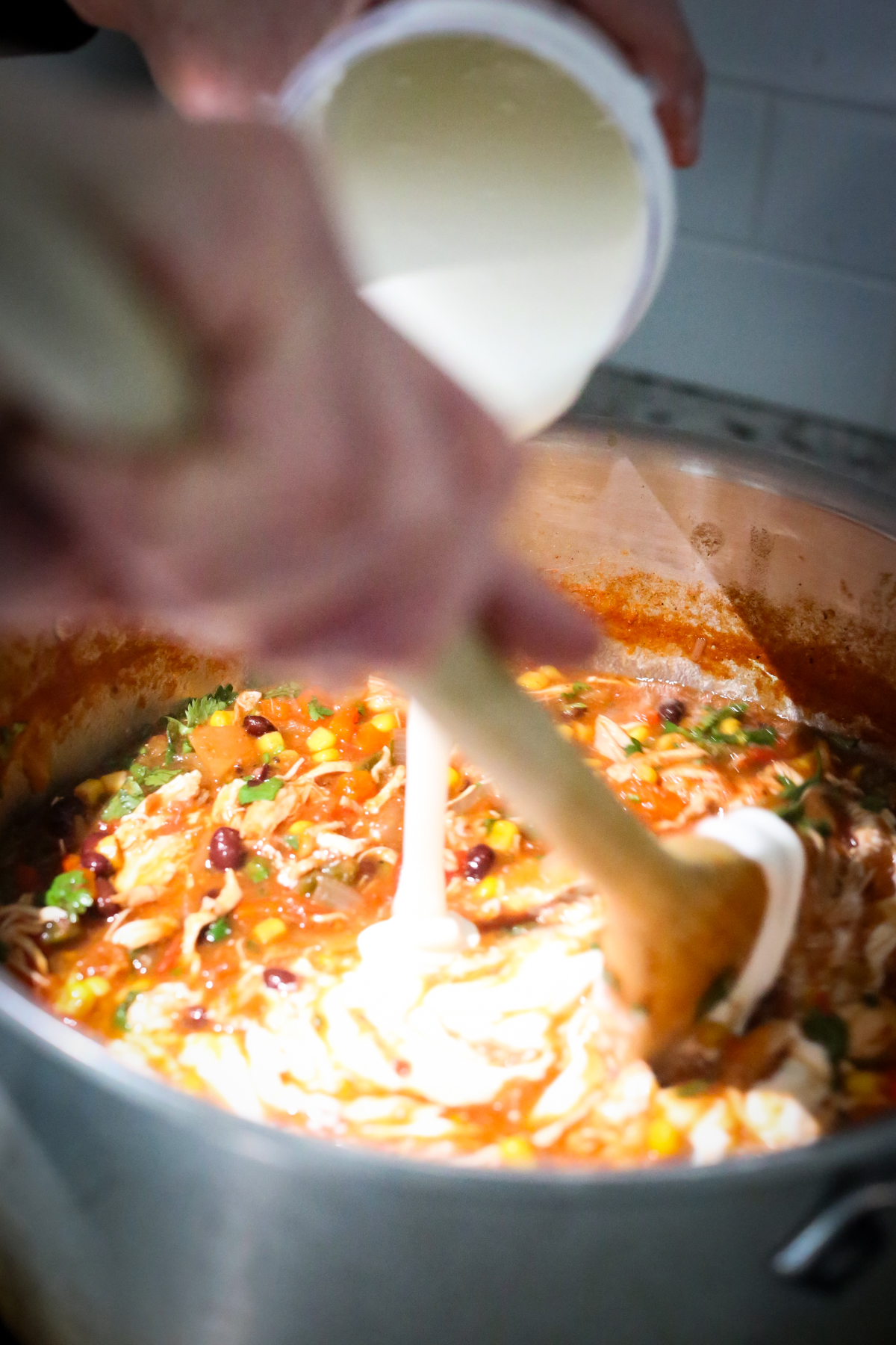 pouring blended cottage cheese into a pot of soup