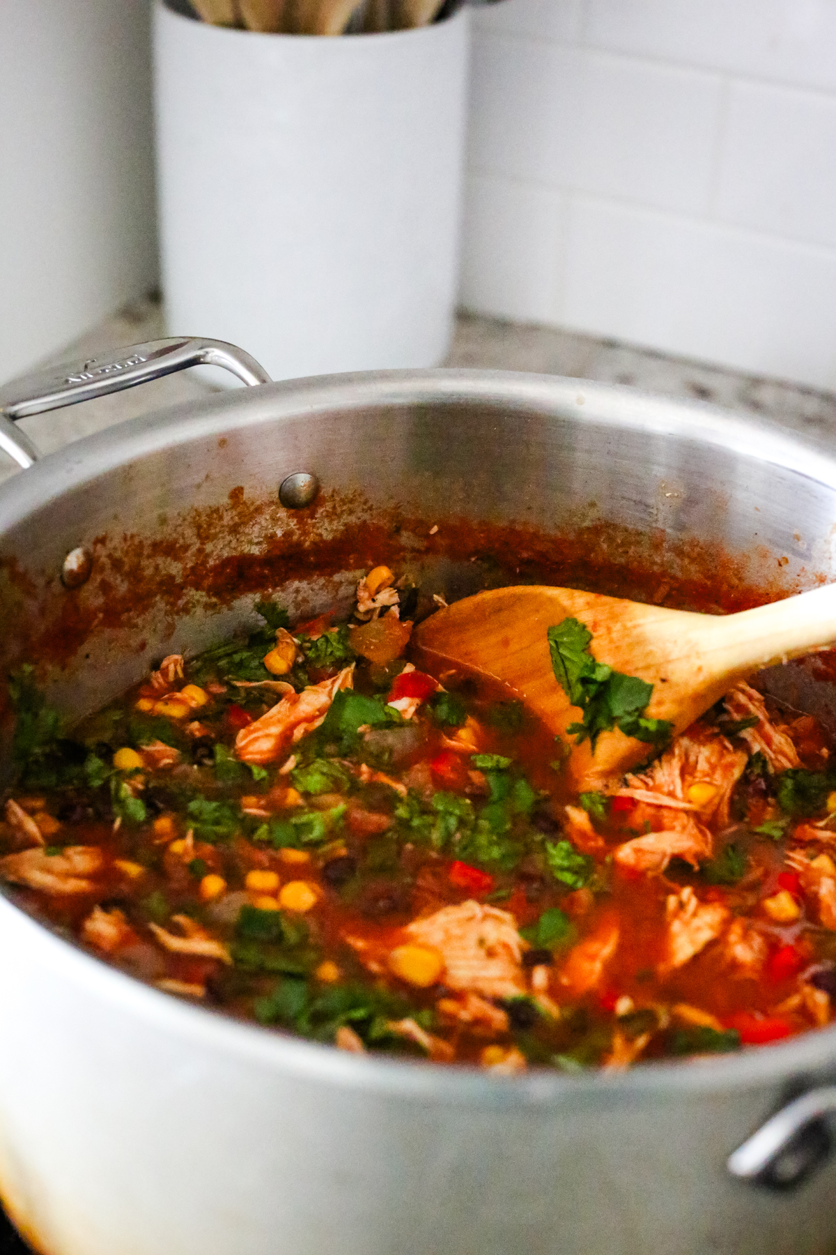 stirring in cilantro leaves to a pot of soup