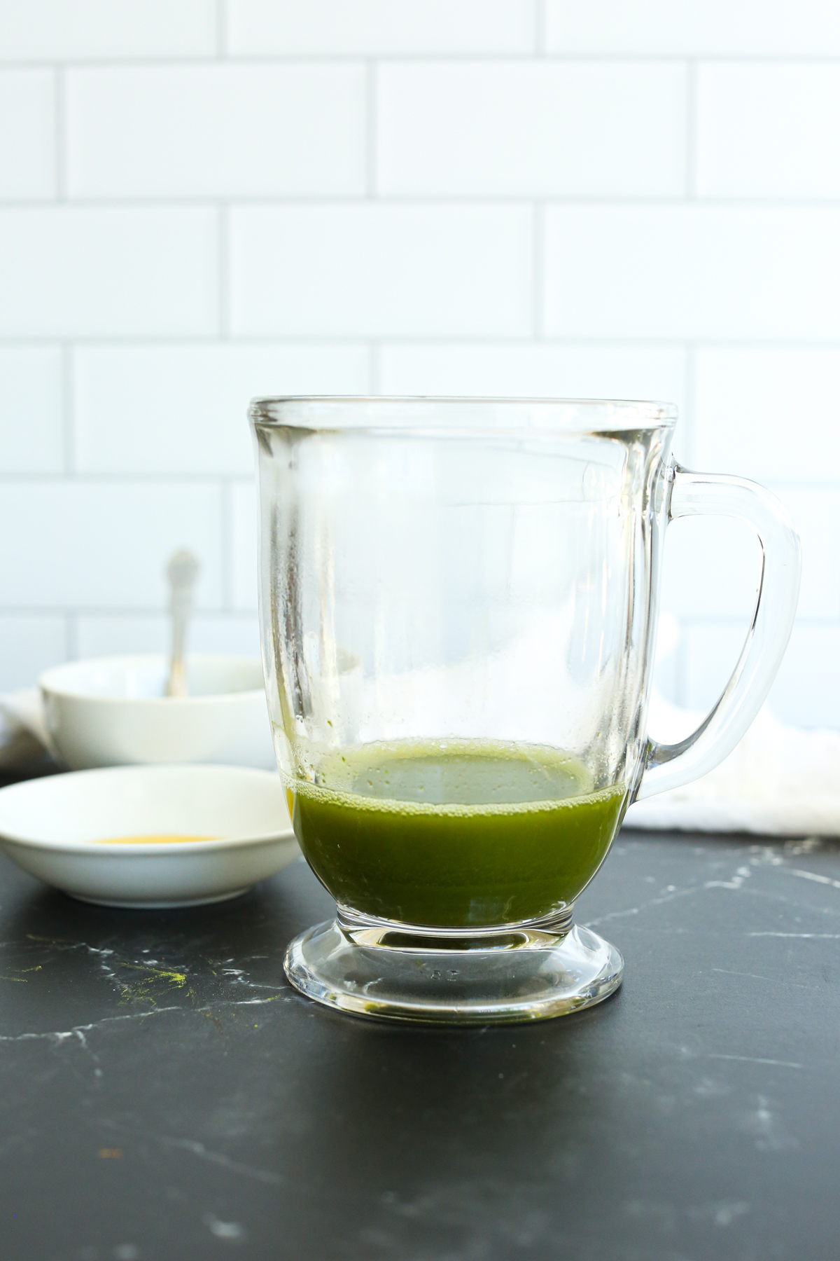 matcha powder combined with hot water in a glass mug