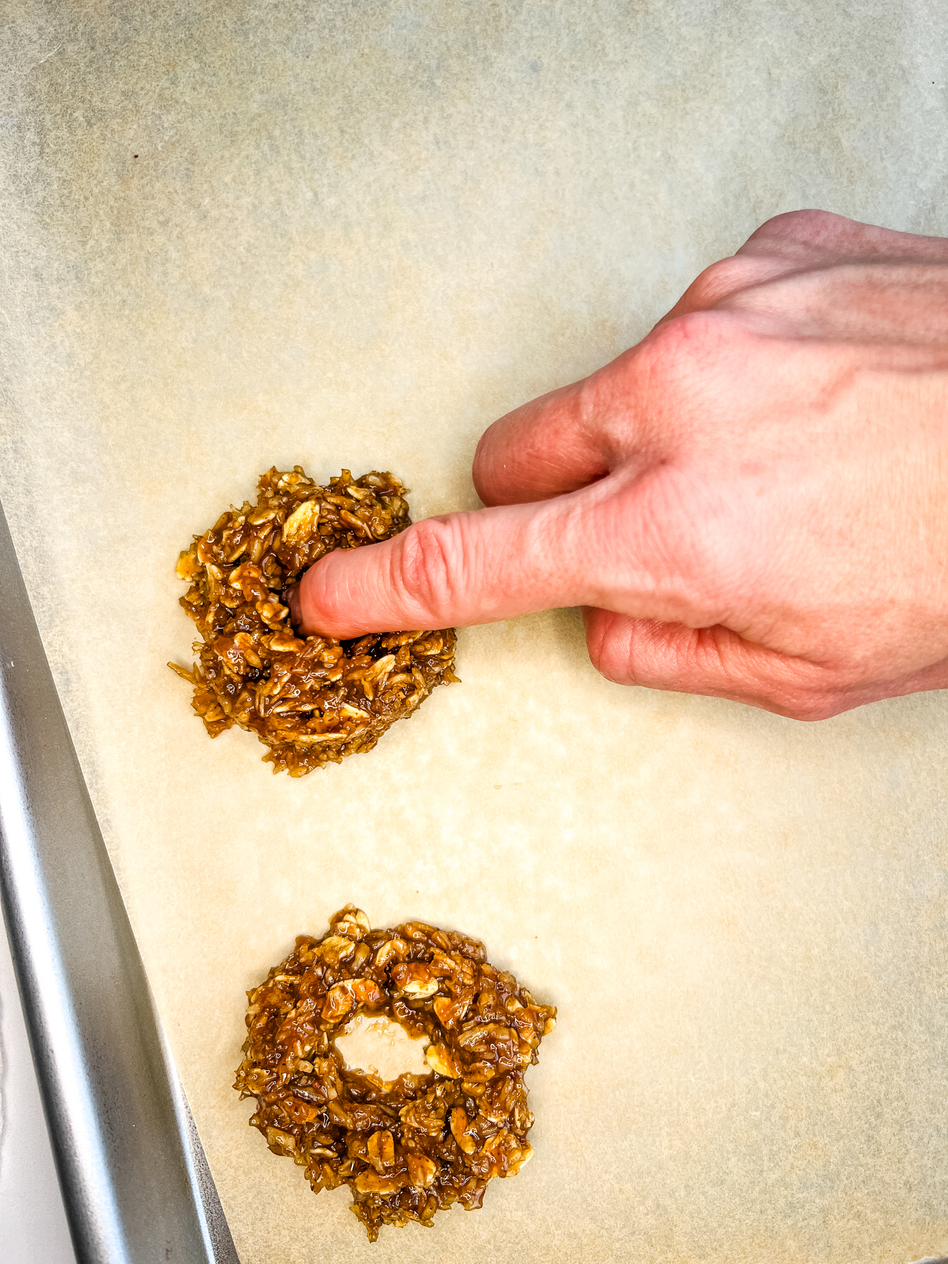 putting a hole in the middle of a cookie on a baking shee