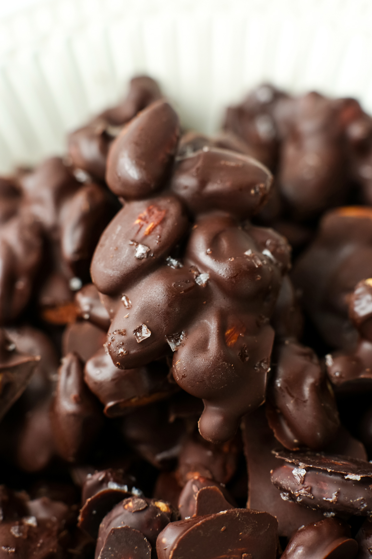a cluster of almonds covered in chocolate with flaked salt on top