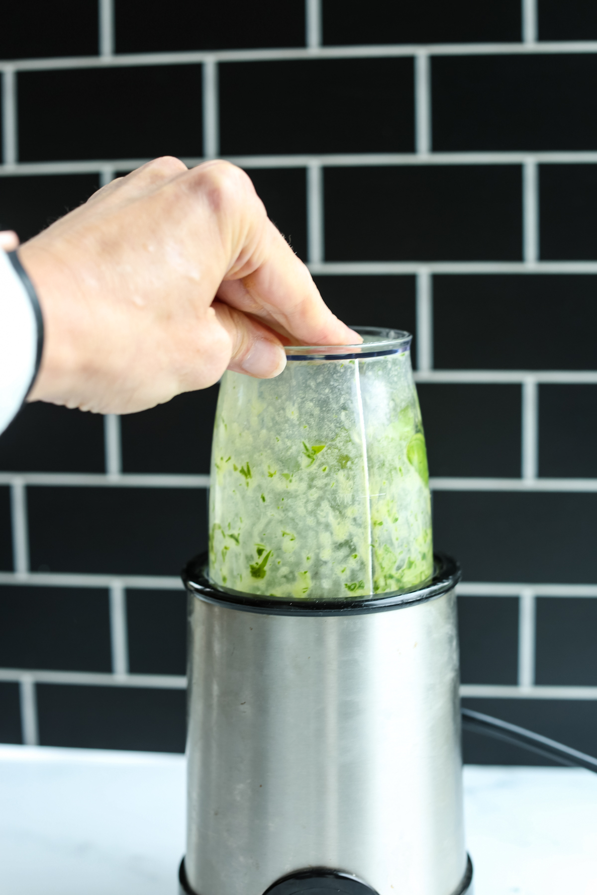 blending the green dressing in a small hand blender