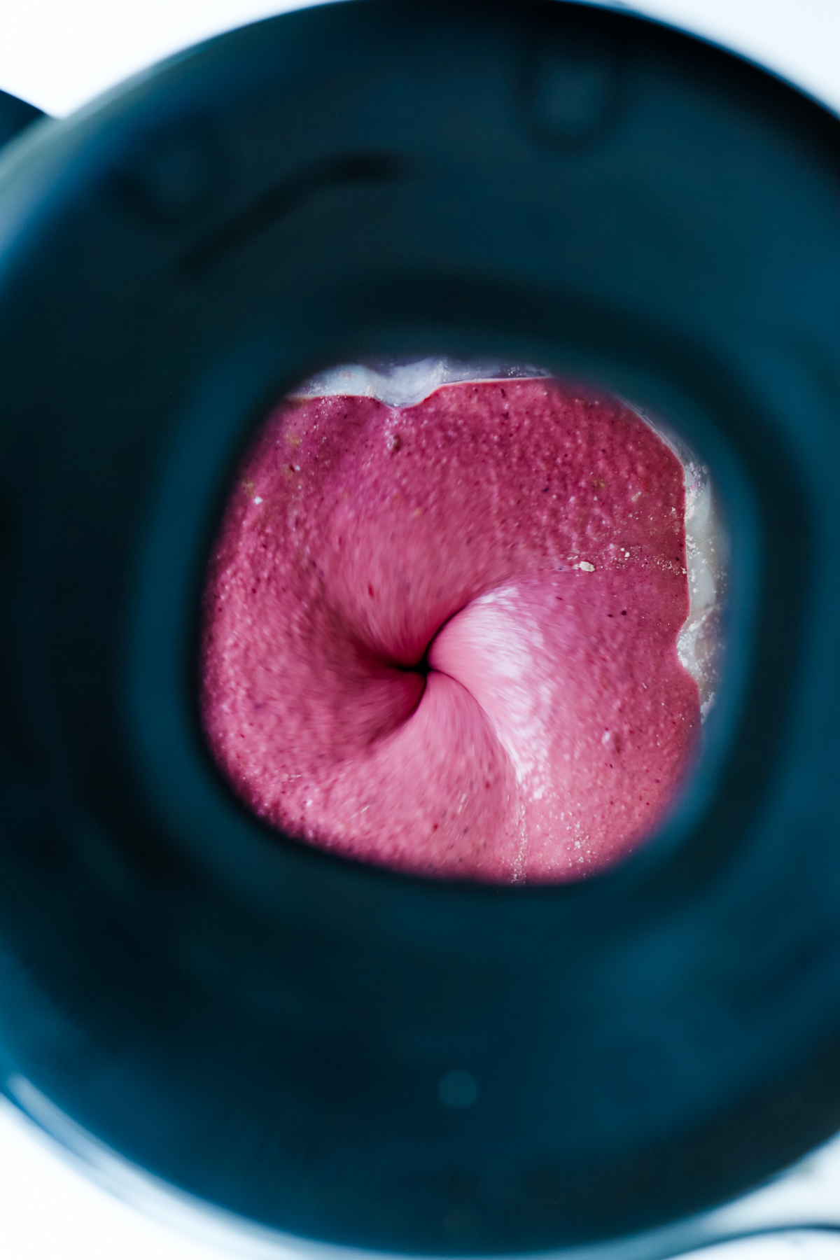 looking into the top of a blender that is blending a smoothie