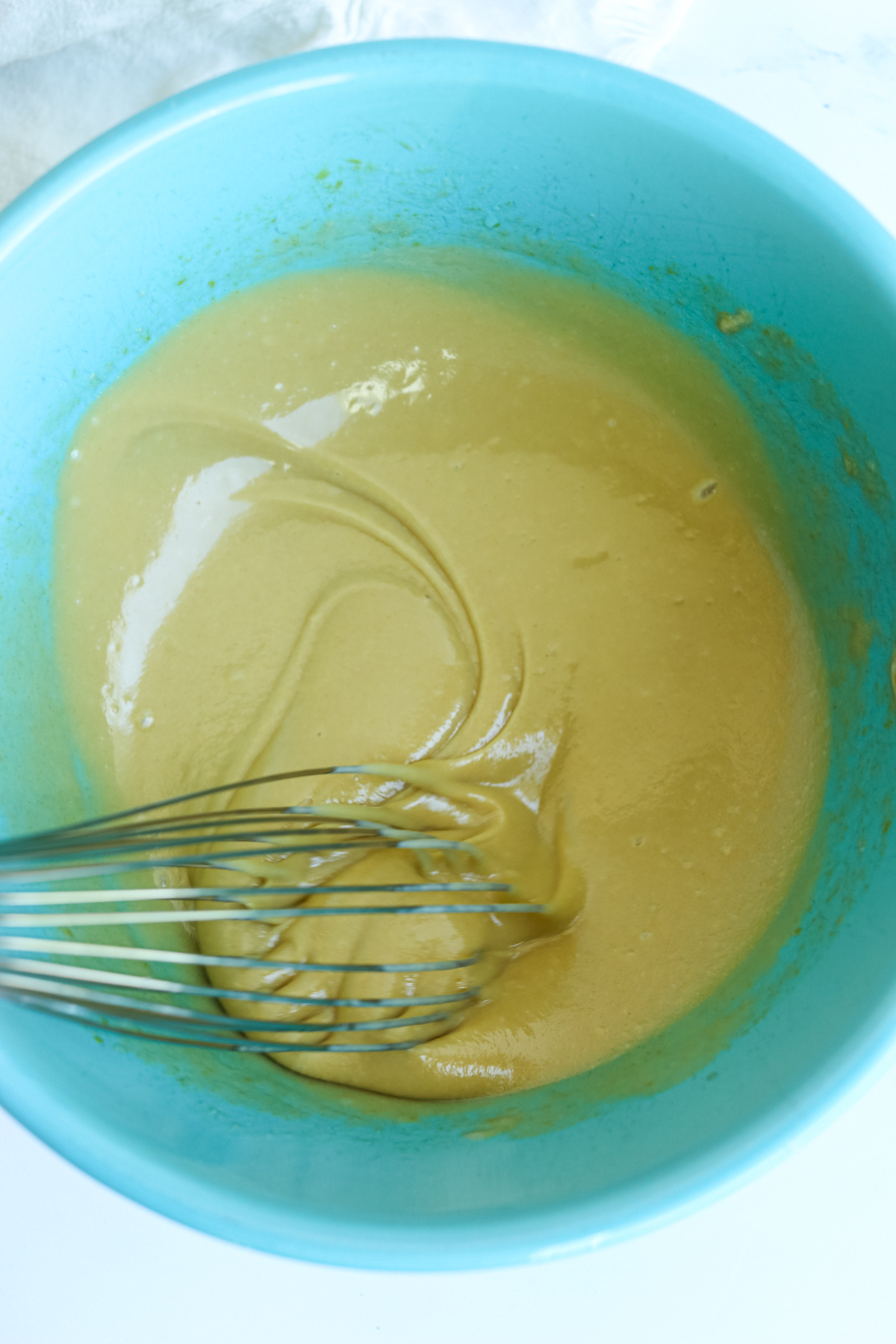 whisking wet ingredients in a turquoise bowl