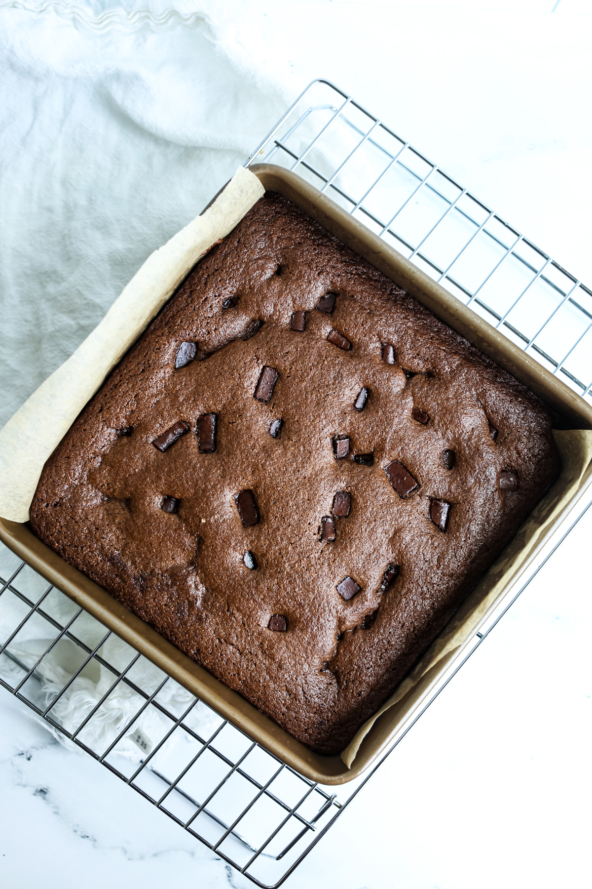 chocolate tahini brownies in pan cooking on a baking rack